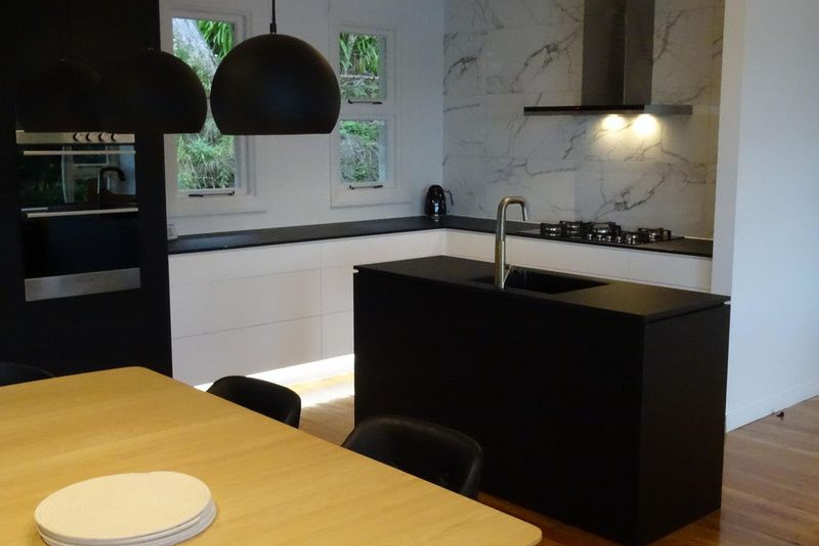 Black kitchen island making a statement in this modern Dunedin kitchen