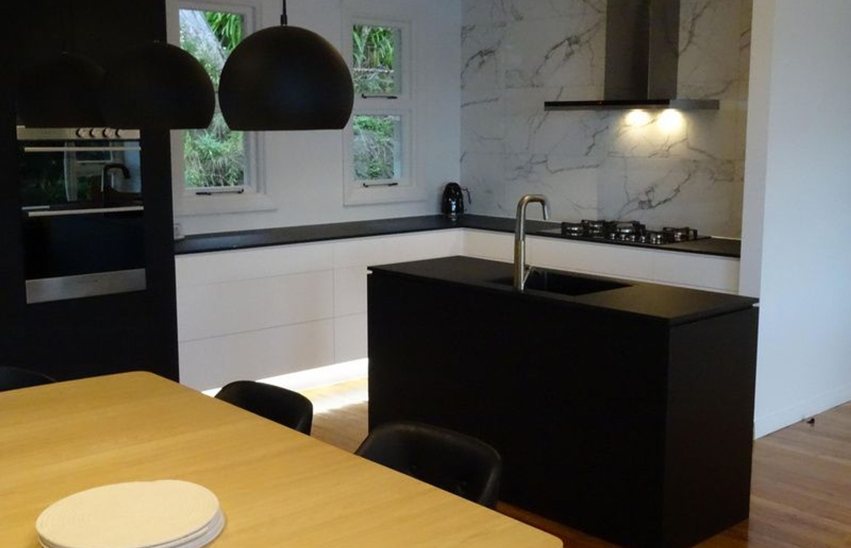 Black kitchen island making a statement in this modern Dunedin kitchen