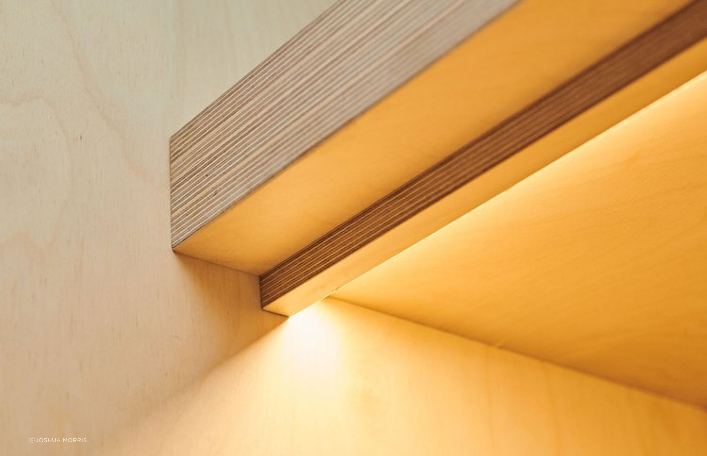 Laminated plywood shelving is lined with LED strip lighting to illuminate the bench top area beneath.