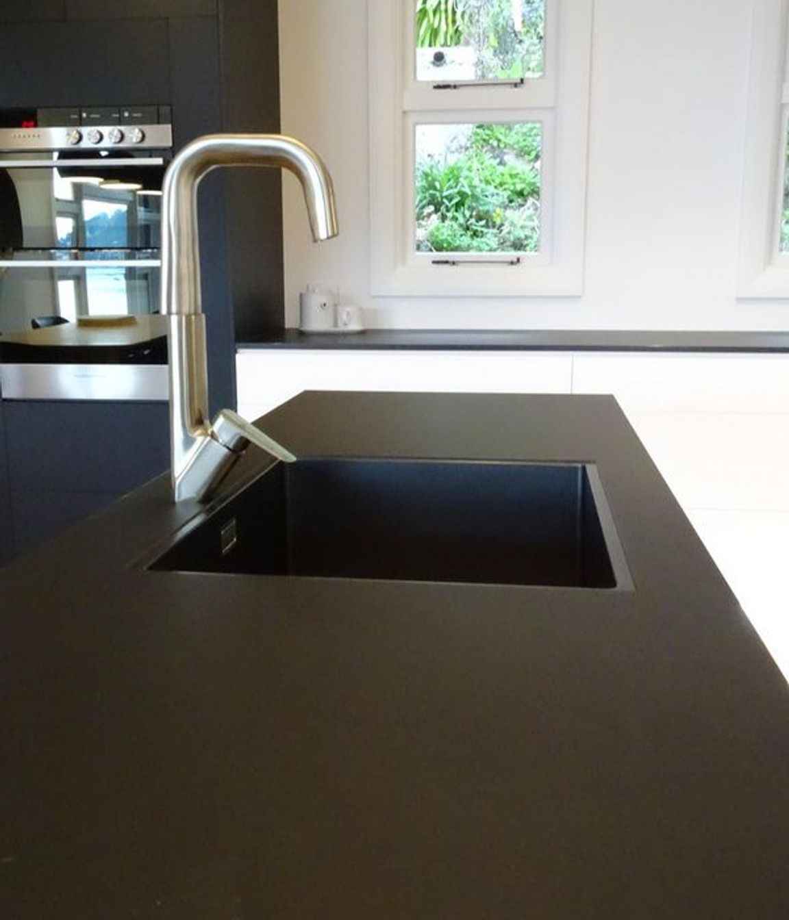 Detail of the black sink with the black kitchen island