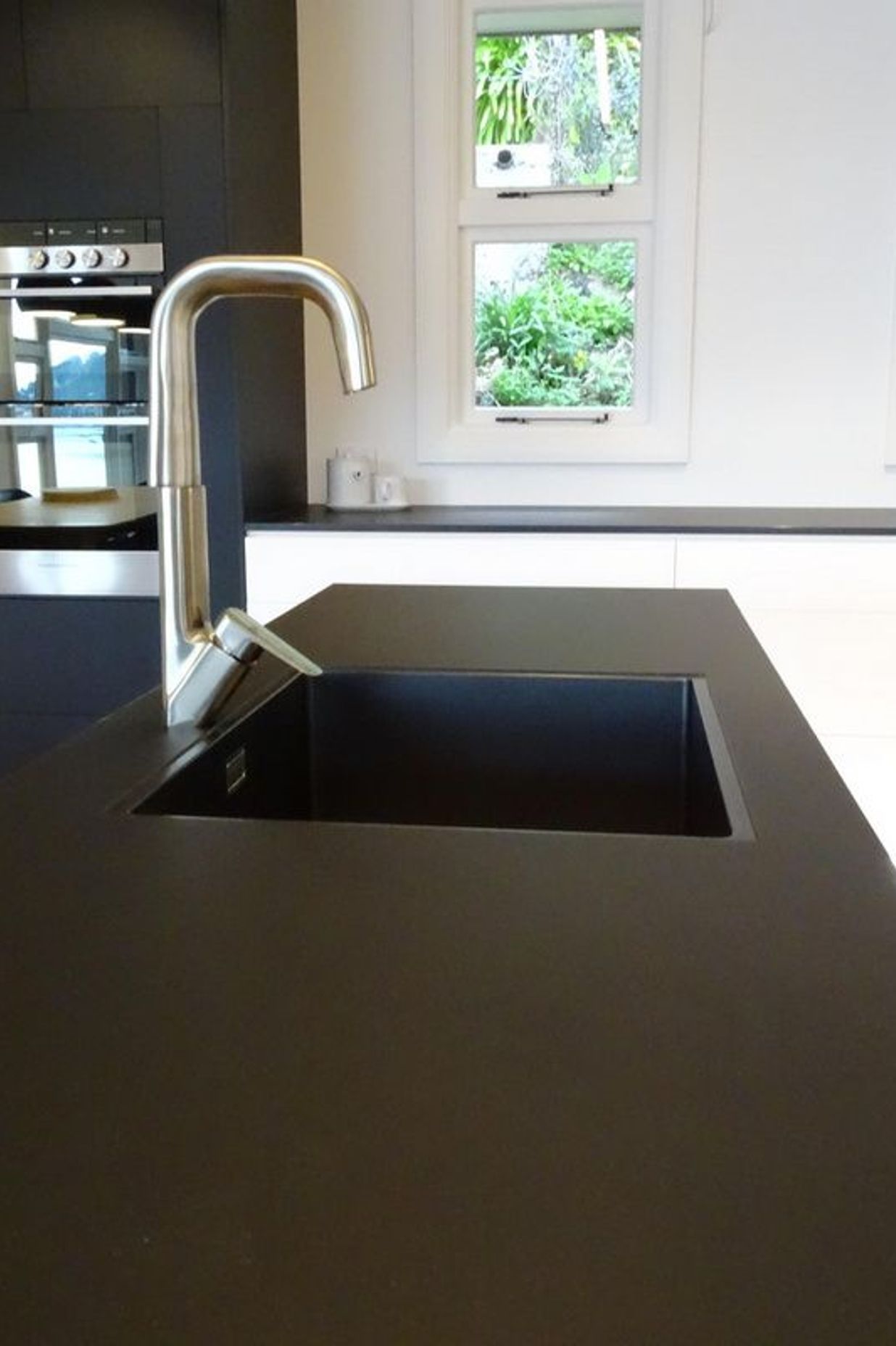 Detail of the black sink with the black kitchen island