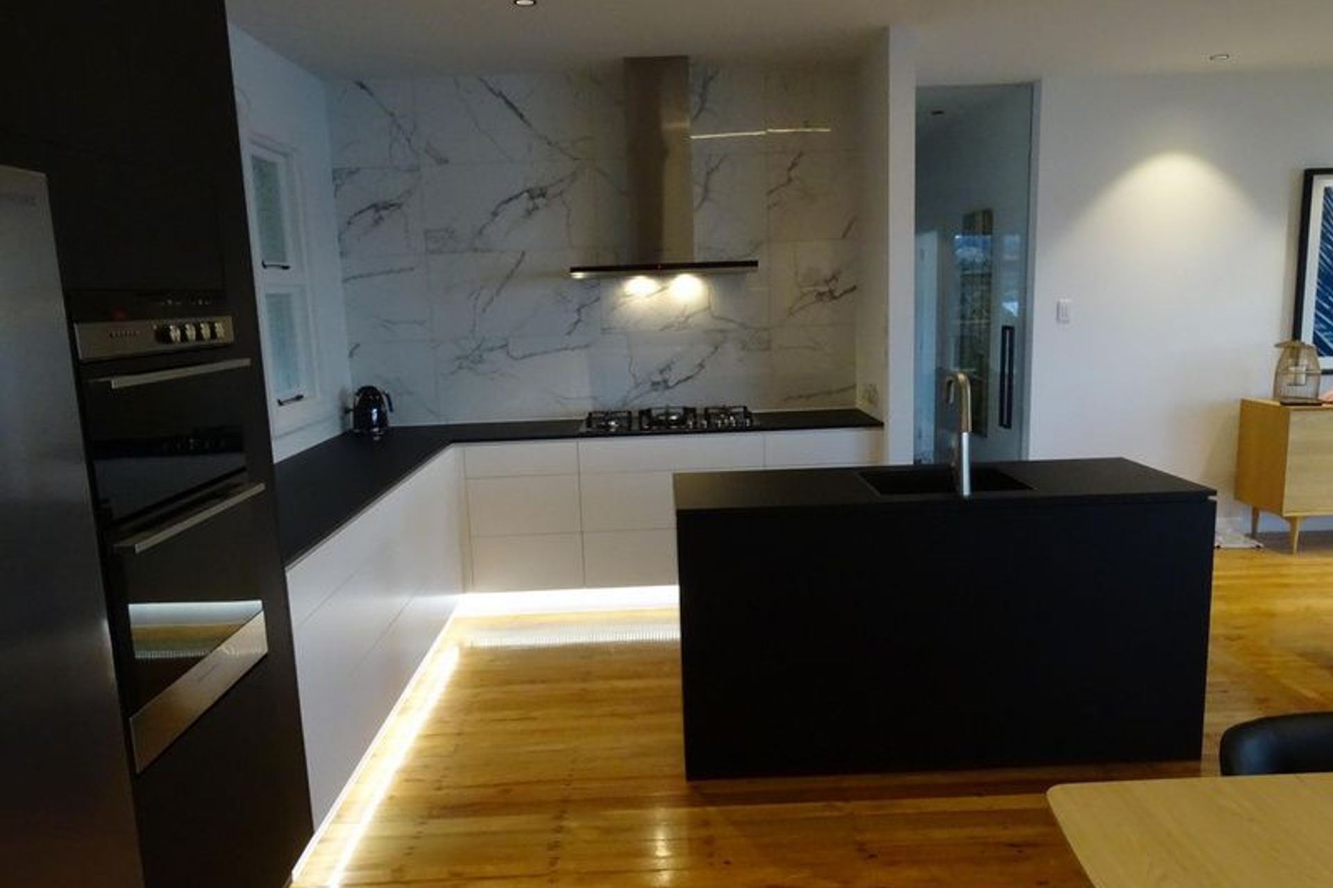 The black bench top, lighting and marble at this modern kitchen in Dunedin