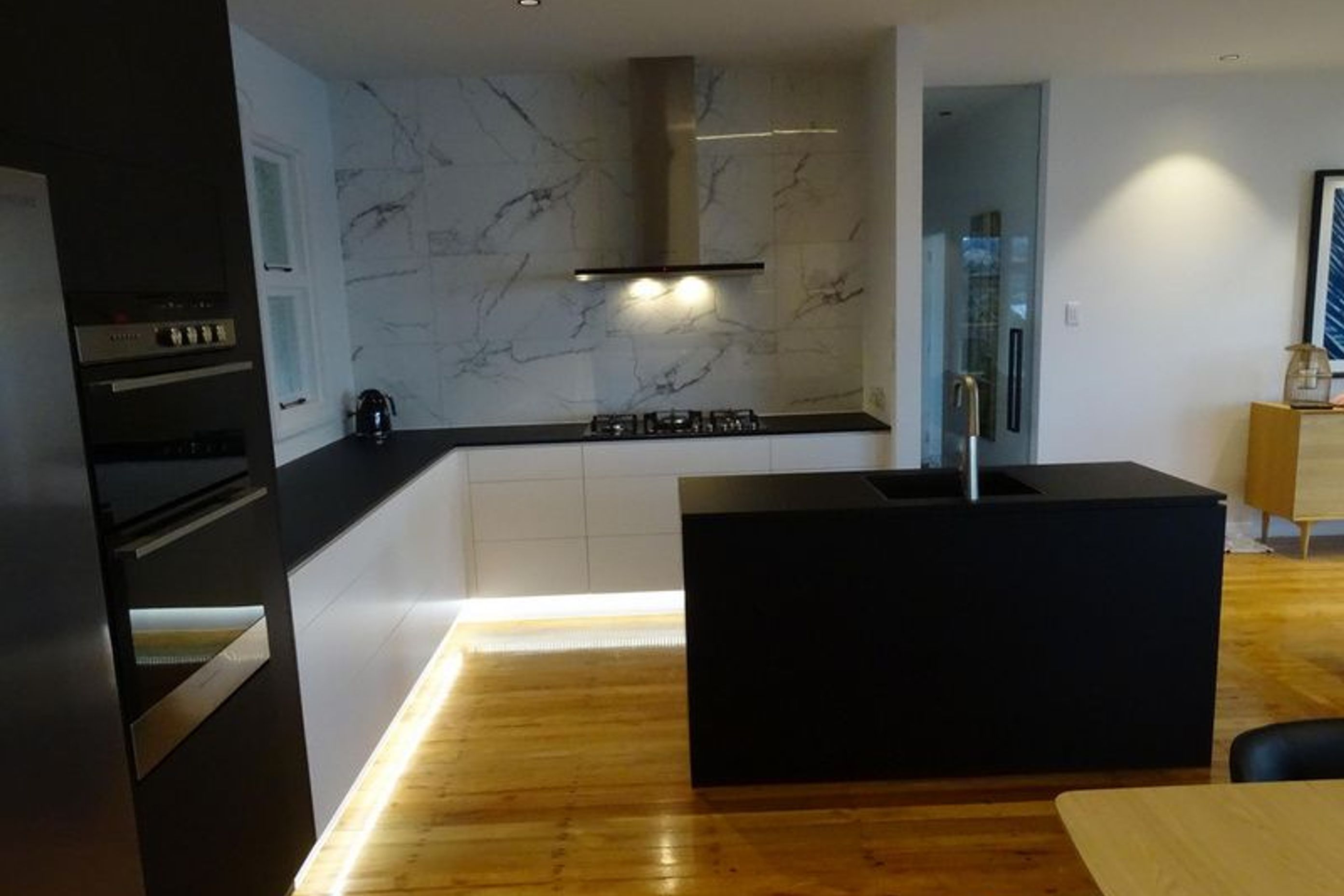 The black bench top, lighting and marble at this modern kitchen in Dunedin