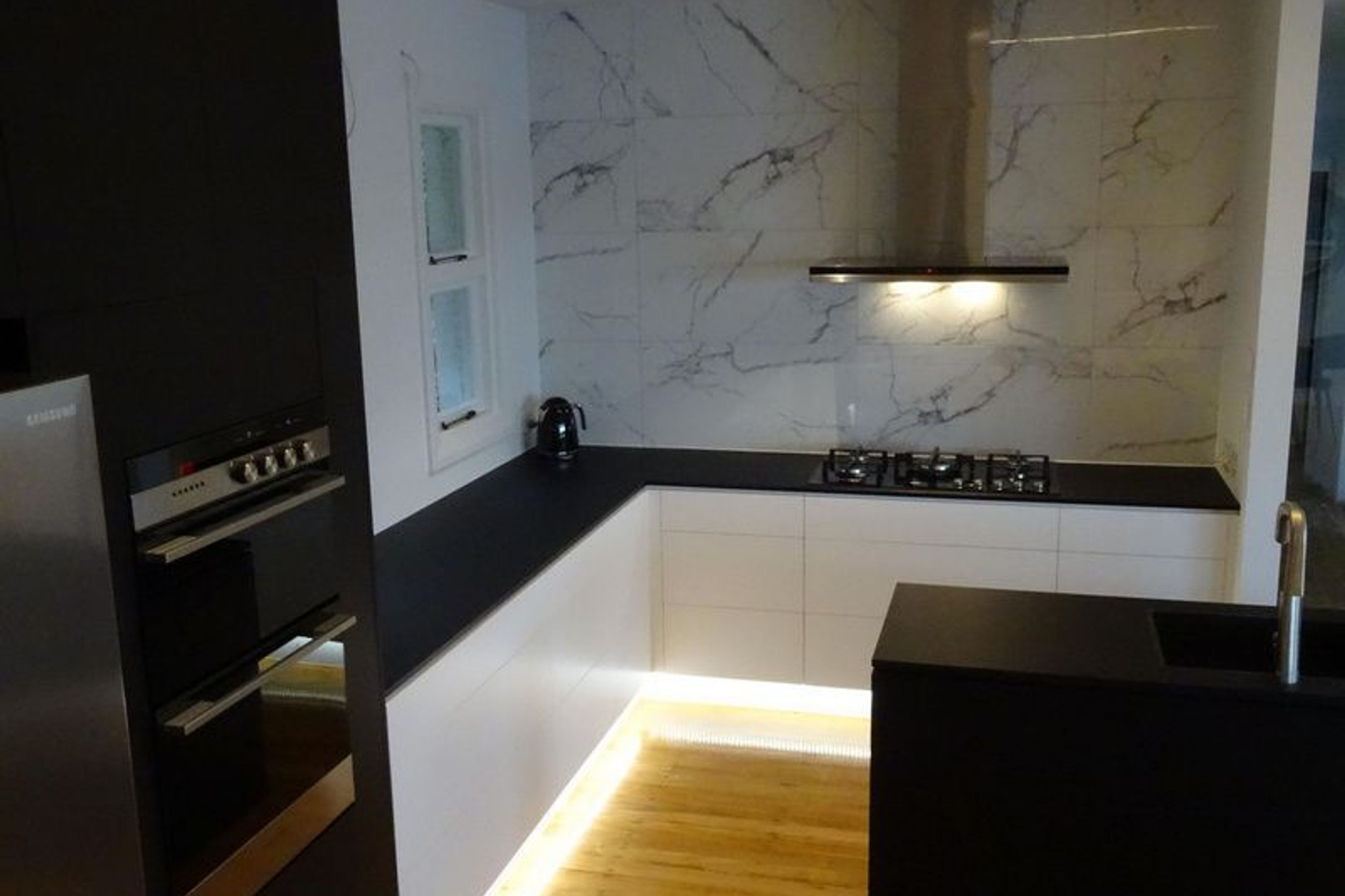 kitchen lighting and cabinetry with marble mix well