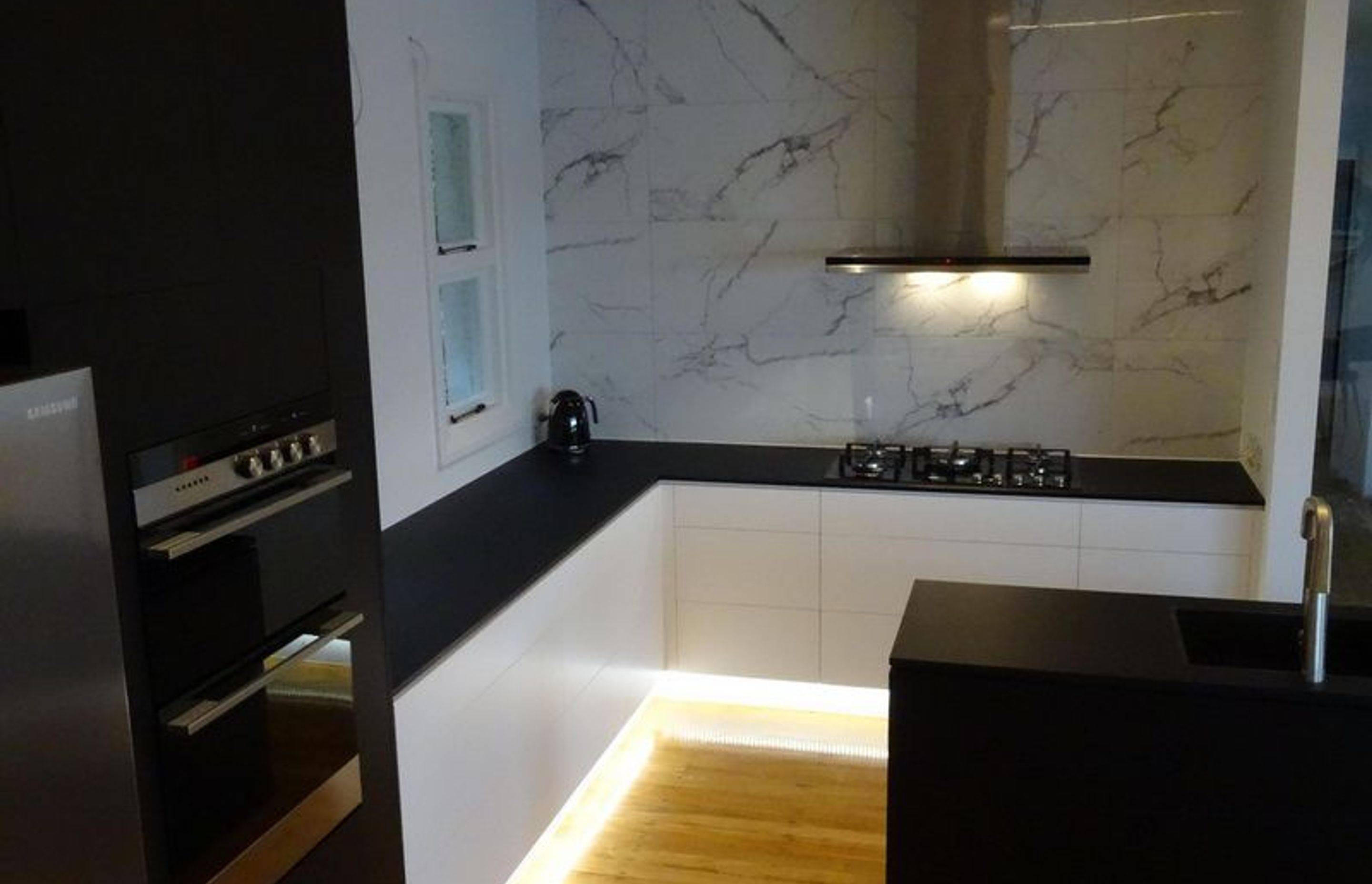 kitchen lighting and cabinetry with marble mix well