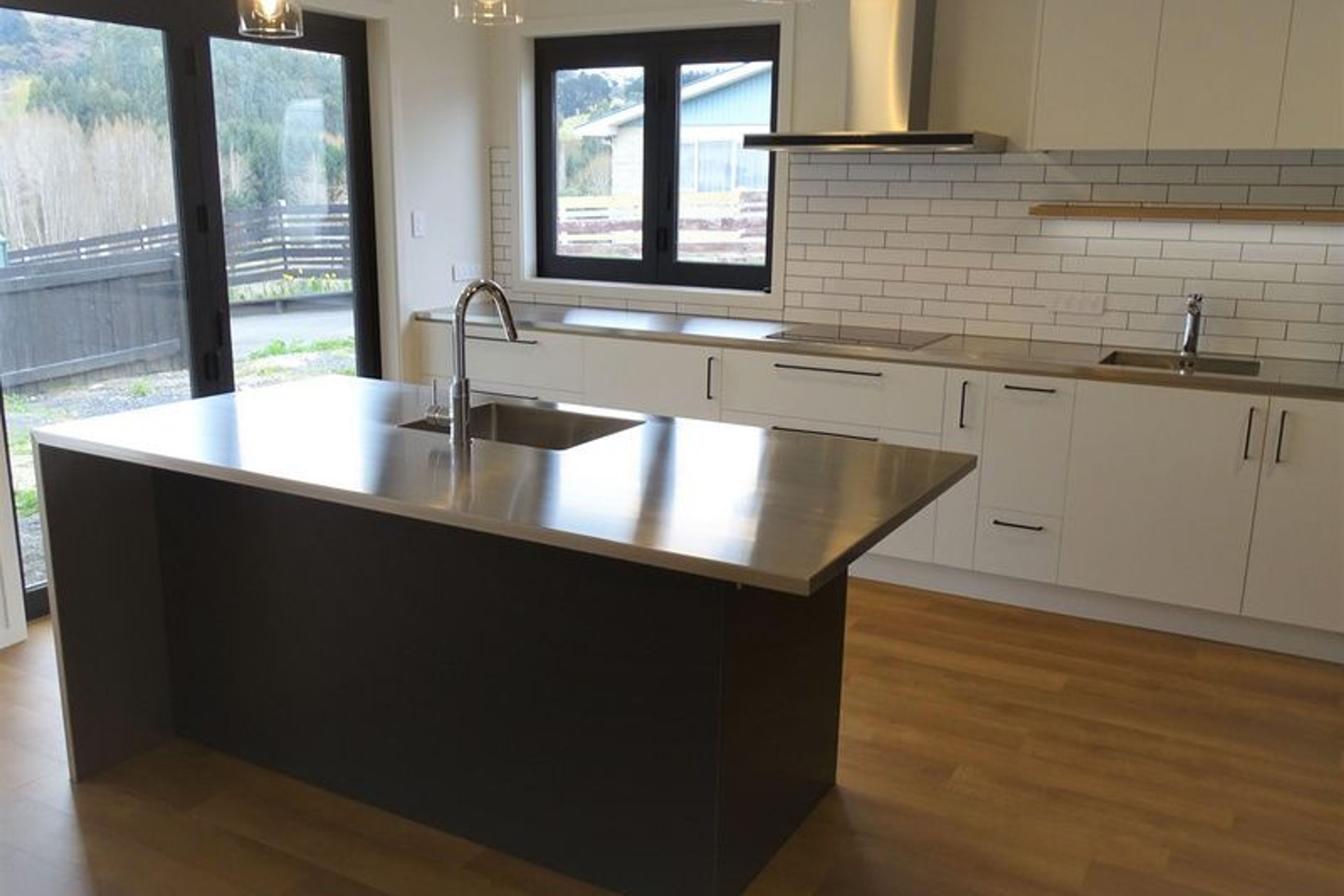 Modern kitchen merging white and black with stainless steel fittings