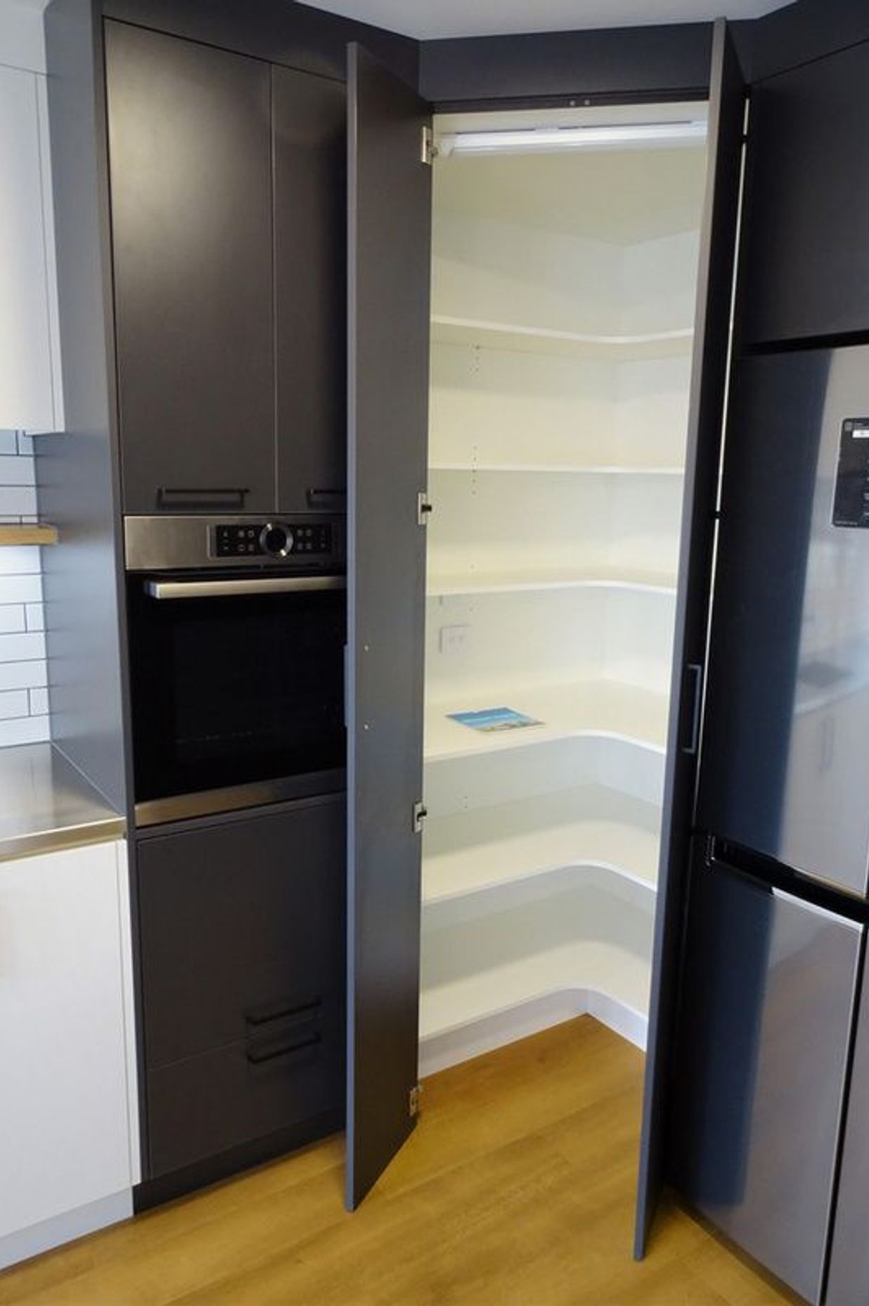 Pantry storage with automatic lighting makes for lots of room in this kitchen
