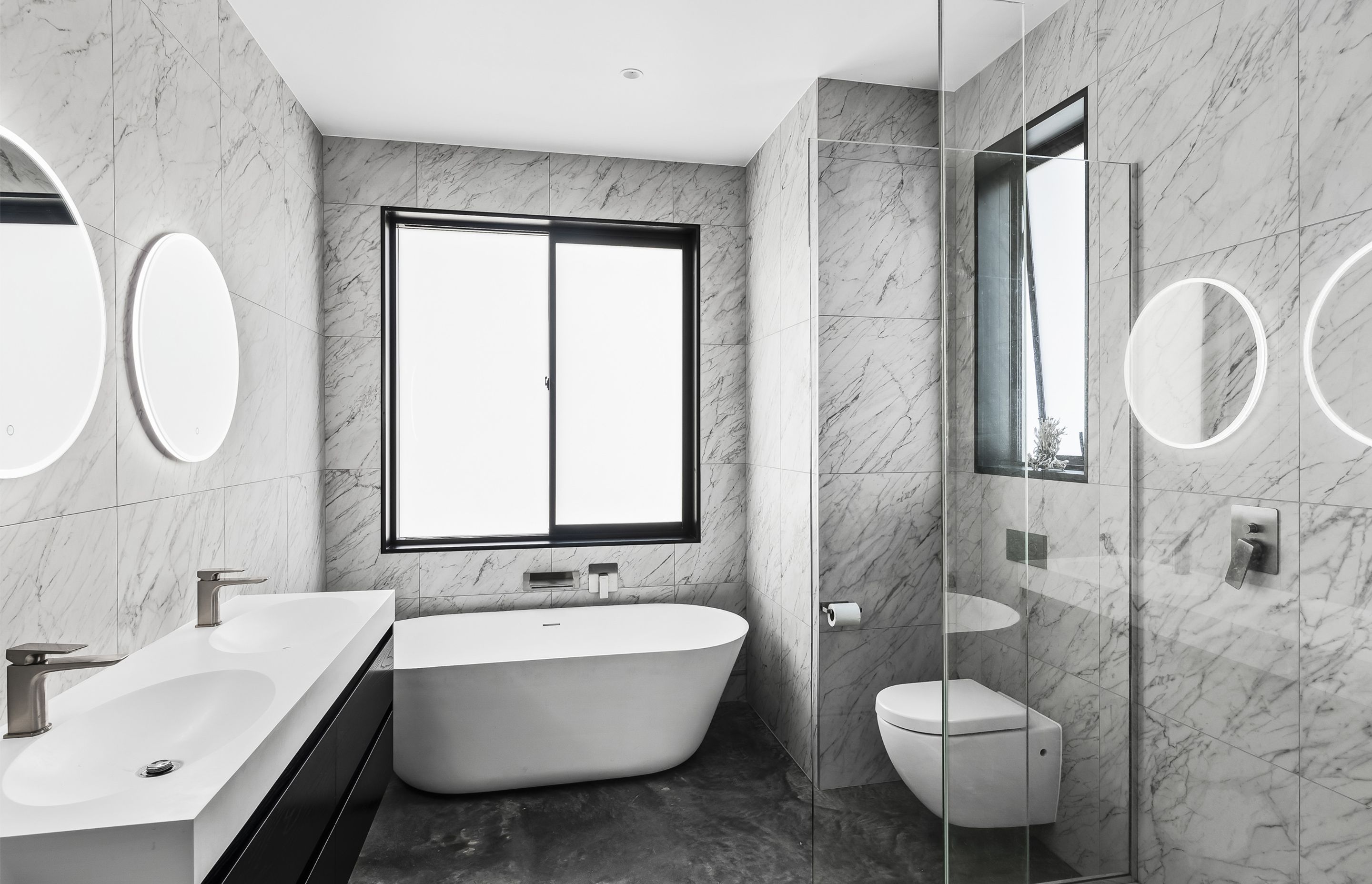 Carrara silver matt tiles and the freestanding bath is Progetto Niagara Ellipse from Plumbline.