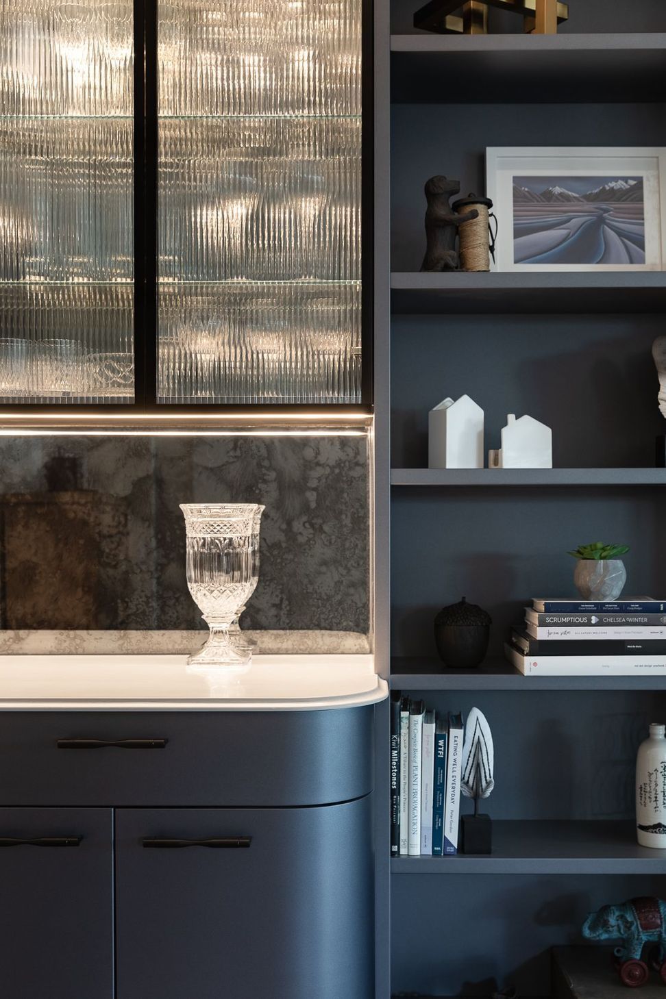 Exquisite lines and curated soft lighting completes the sophisticated design. Located opposite the kitchen, the bar leads on to an outdoor entertainment room complete with fireplace, wall heaters, a movie screen and integrated BBQ.