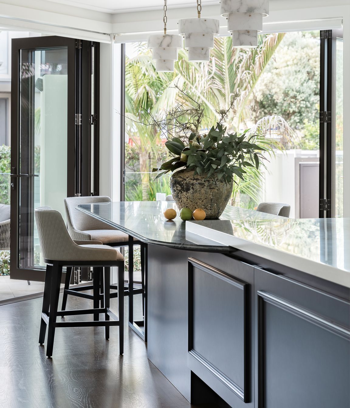 Vital storage continues under the island while casual dining to the table end offers visual connection to the pool and sun-drenched courtyard.