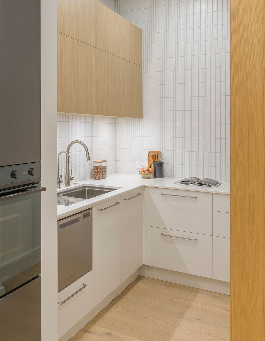 Meeting the client’s wish for the messy functions of baking and juicing, an open scullery is discreetly located behind; fitted with a sparkling chilled water tap and an overflow dishdrawer. Its materiality reiterates the kitchen in highly serviceable yet realistic Melteca surfaces from Laminex.