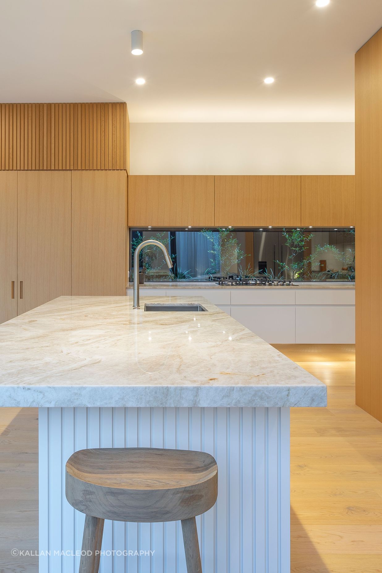 Bench tops feature an elegantly patterned quartzite, chosen for its serene beauty and earth-real character. Hand-picked at the suppliers, the Champagne stone with its textural grain and golden hues complement the oak cabinetry and waterbourne-finished floors beautifully.