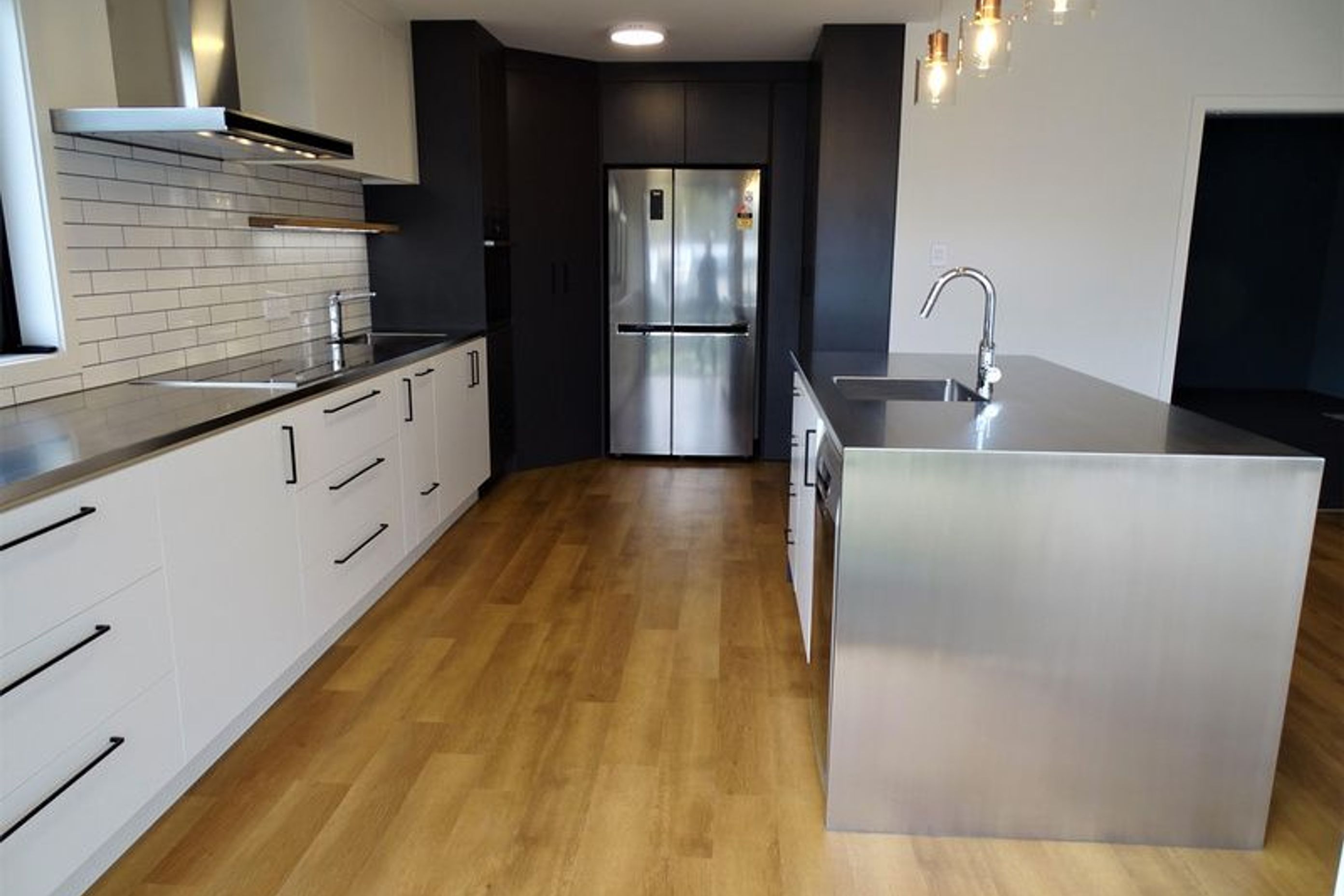 Stainless steel white black and wood make a modern kitchen design