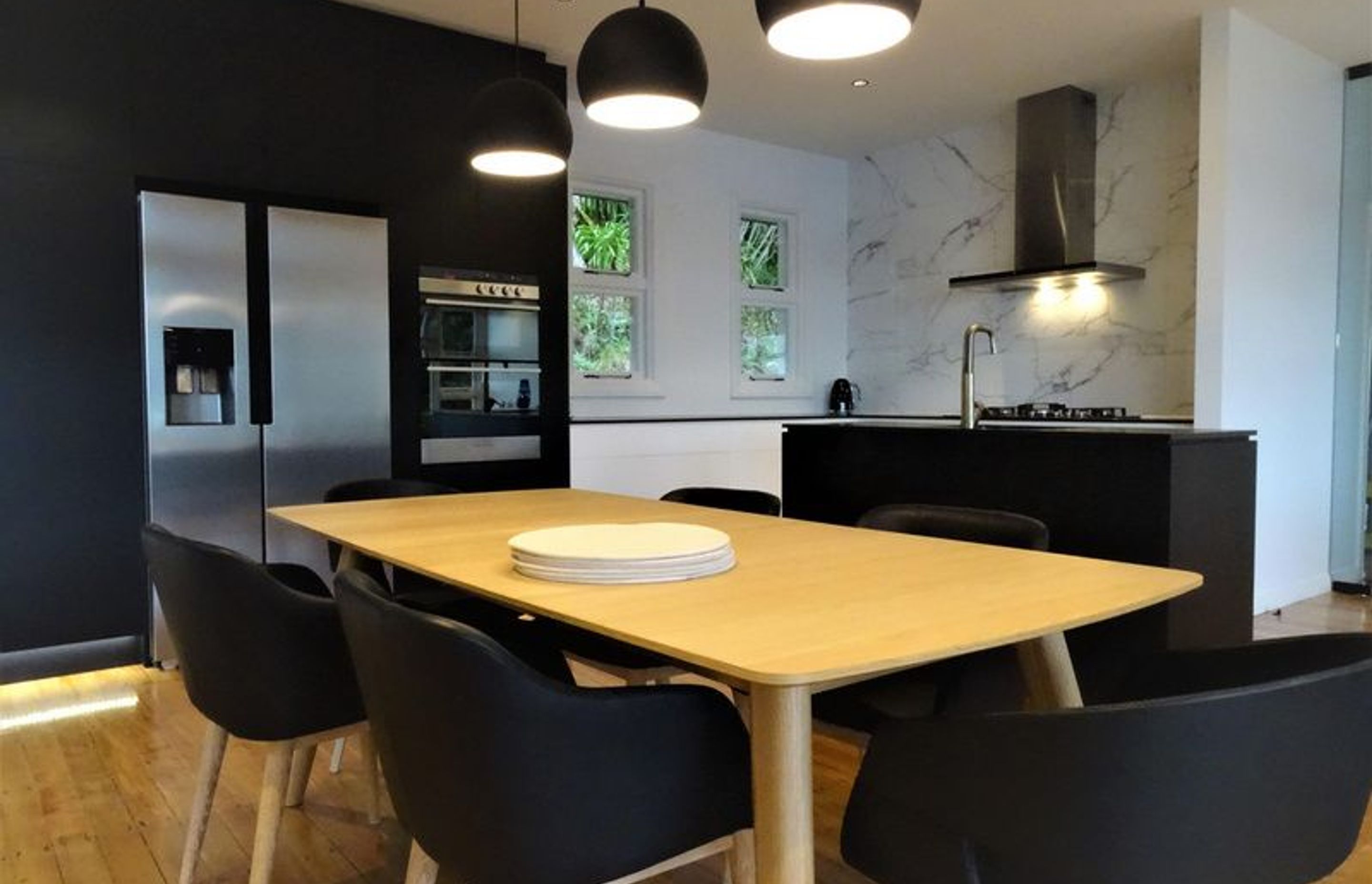 The black cabinetry, lighting and marble splash back tie in together