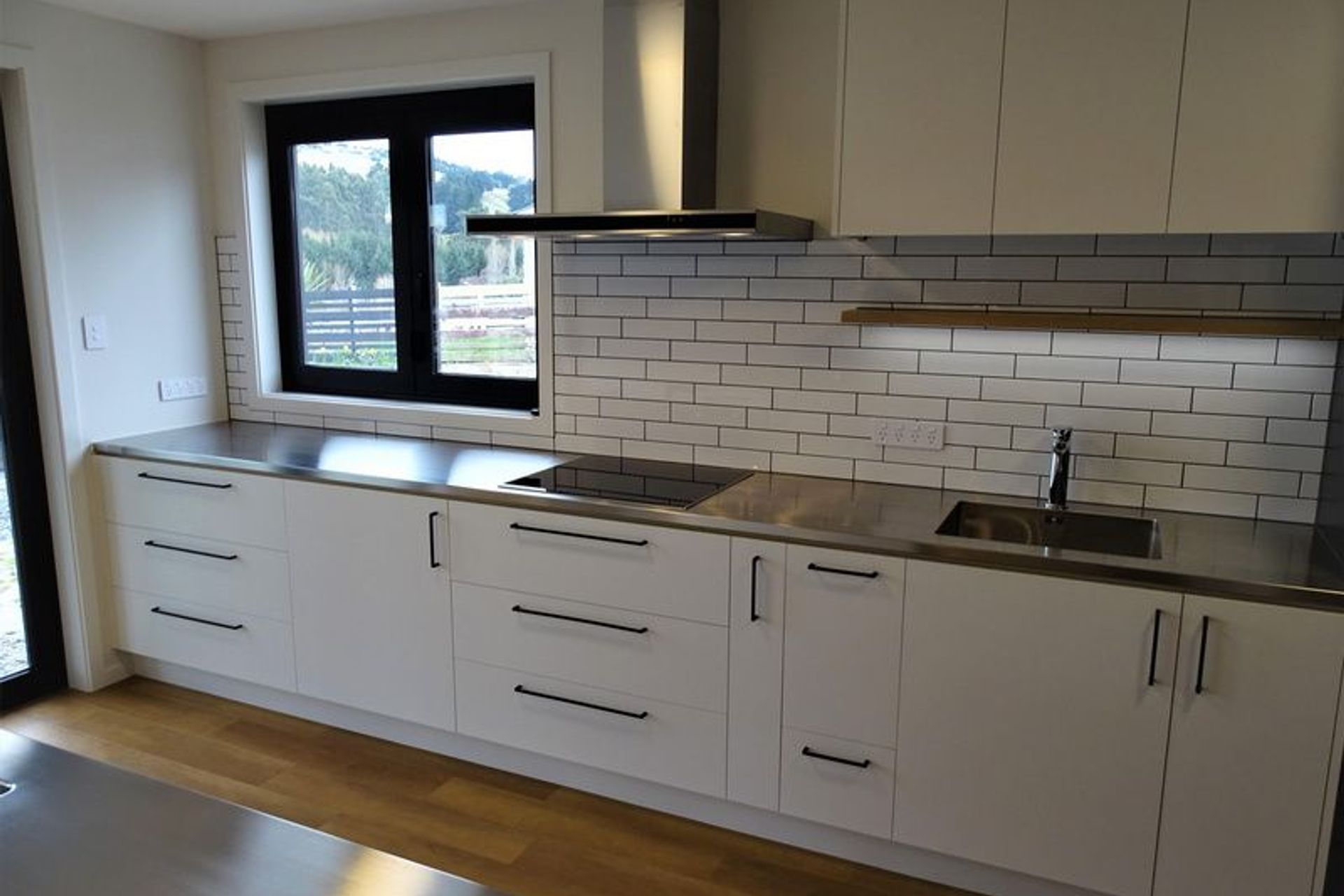 The lighting and black fittings on this kitchen cabinetry by Ron Kirk Joinery