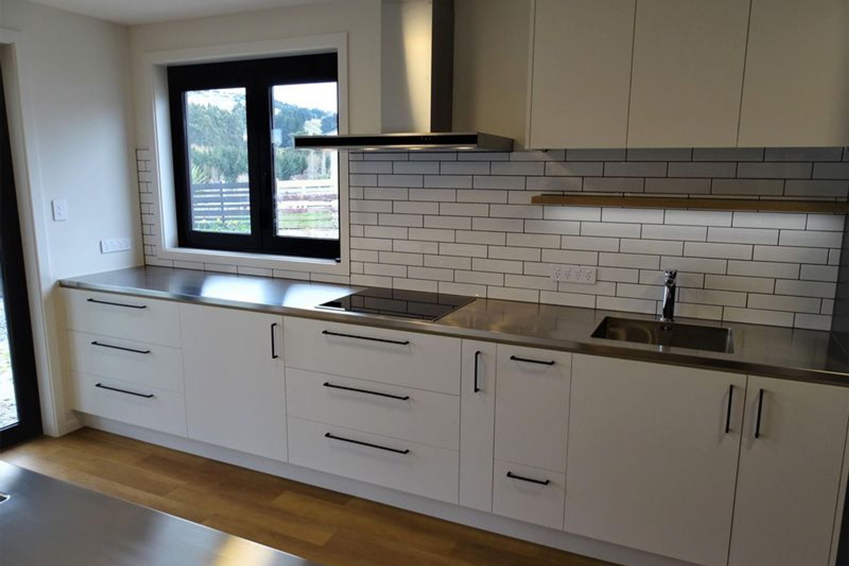 The lighting and black fittings on this kitchen cabinetry by Ron Kirk Joinery