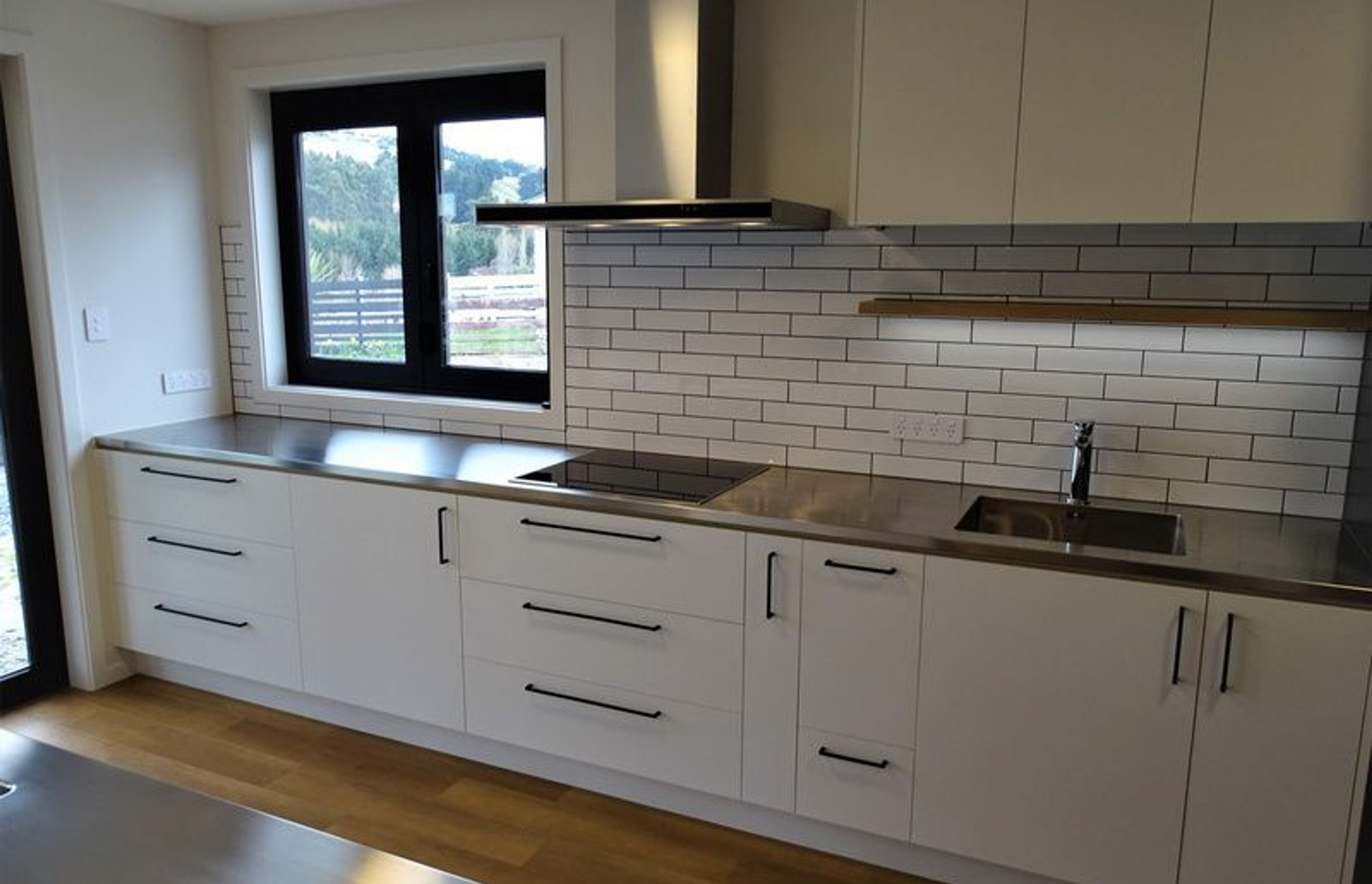 The lighting and black fittings on this kitchen cabinetry by Ron Kirk Joinery