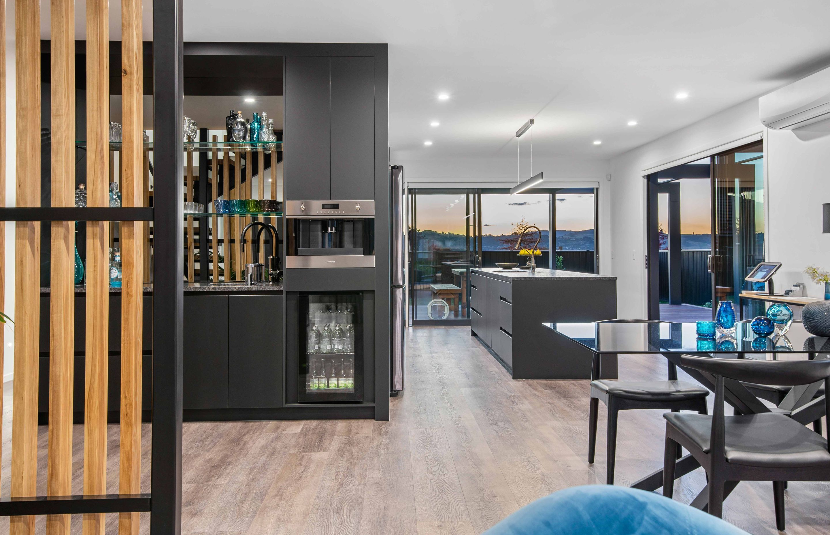 Adjacent to the kitchen is a separate bar area featuring a polished granite benchtop, smoky mirrored splashback and integrated coffee machine and wine fridge.
