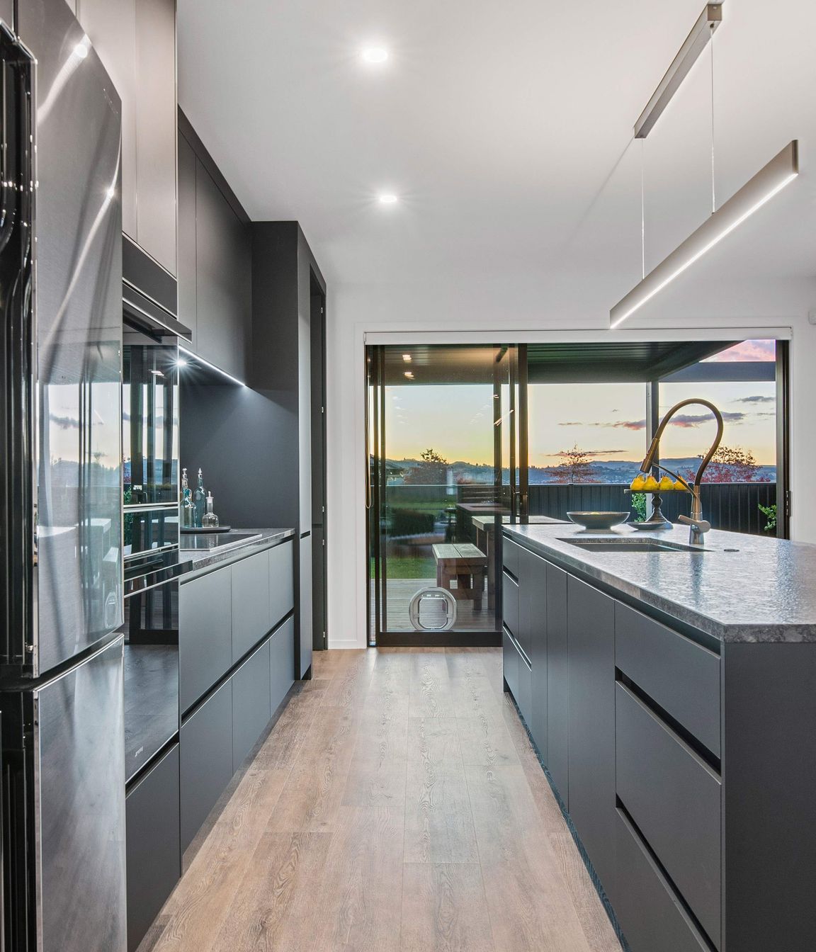 The designer kitchen incorporates a concealed scullery and has elegant finishes such as soft-close black acrylic melteca cabinetry, marble statuario splashback, Smeg appliances, an advanced Dorf Inca tap and a leathered granite benchtop.