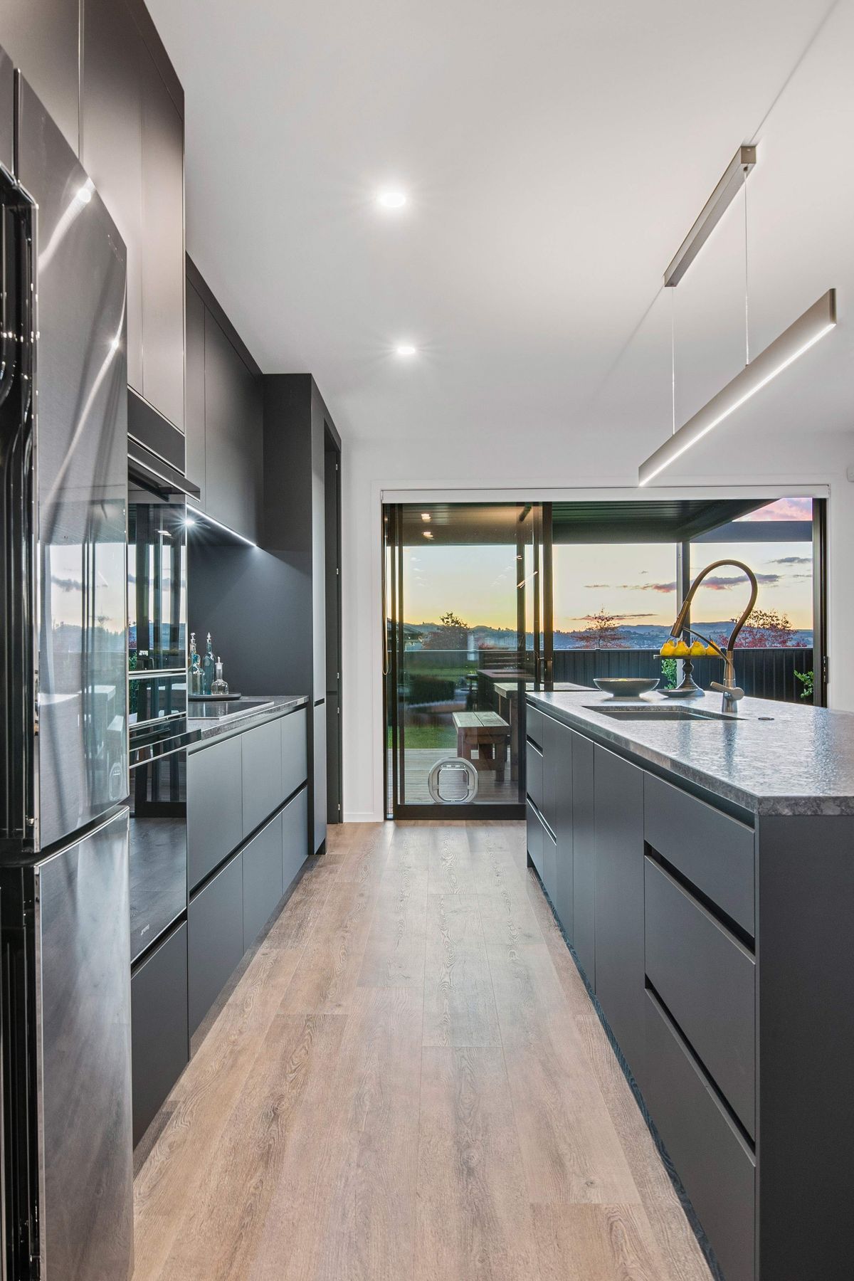 The designer kitchen incorporates a concealed scullery and has elegant finishes such as soft-close black acrylic melteca cabinetry, marble statuario splashback, Smeg appliances, an advanced Dorf Inca tap and a leathered granite benchtop.