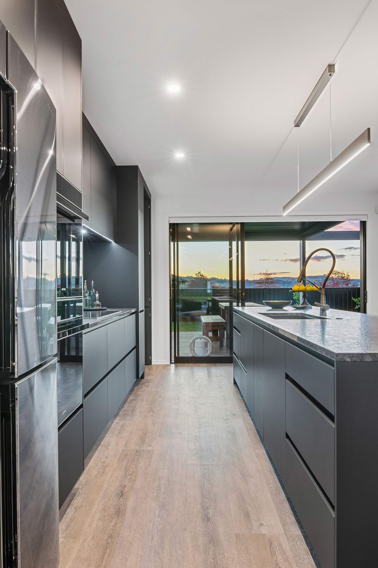 The designer kitchen incorporates a concealed scullery and has elegant finishes such as soft-close black acrylic melteca cabinetry, marble statuario splashback, Smeg appliances, an advanced Dorf Inca tap and a leathered granite benchtop.