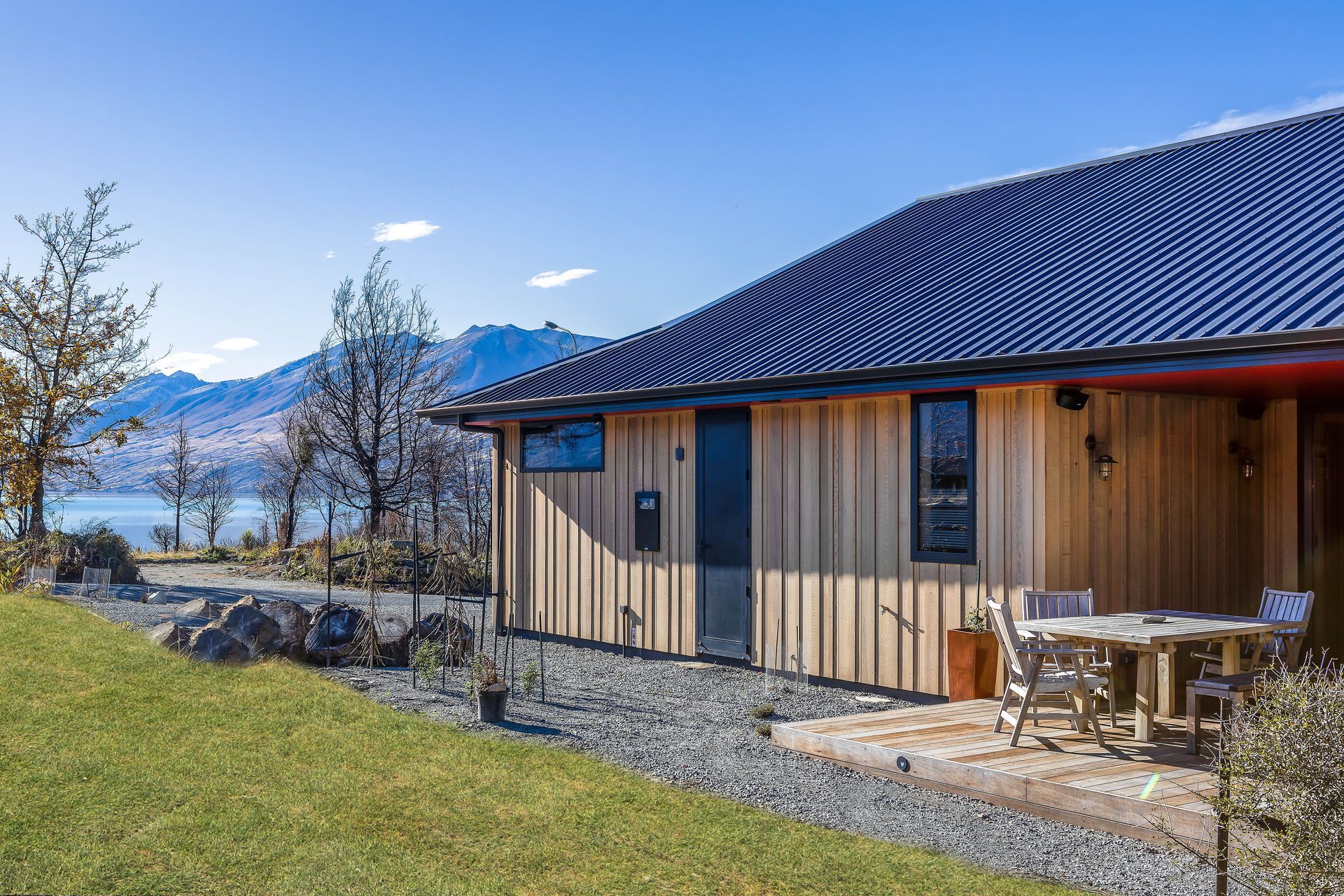 Clad in a random-width-and-depth vertical cedar board, the north-east corner of this home is wrapped in schist. The owners love to sit on the deck in the morning sun watching the world go by.