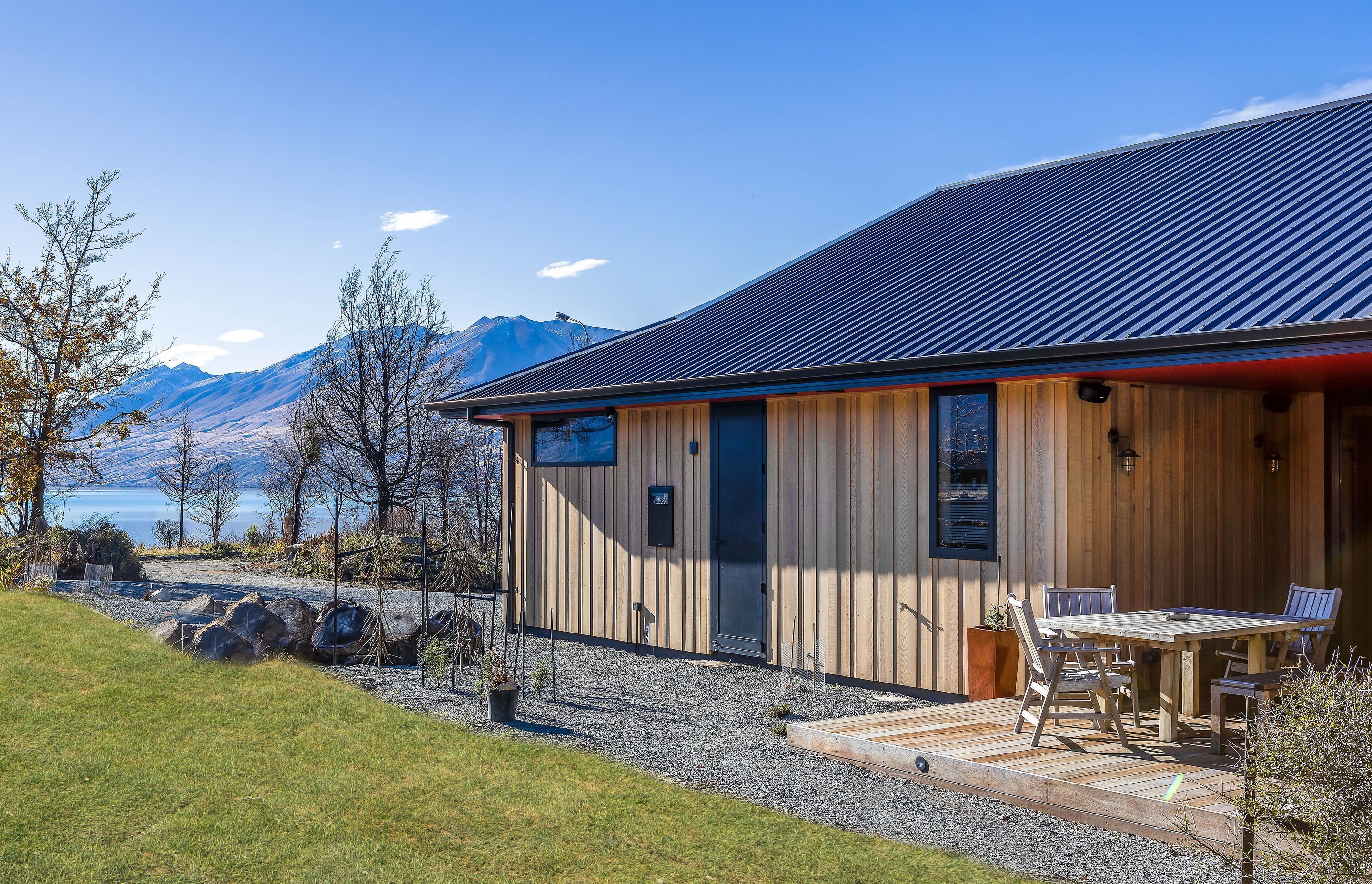 Clad in a random-width-and-depth vertical cedar board, the north-east corner of this home is wrapped in schist. The owners love to sit on the deck in the morning sun watching the world go by.