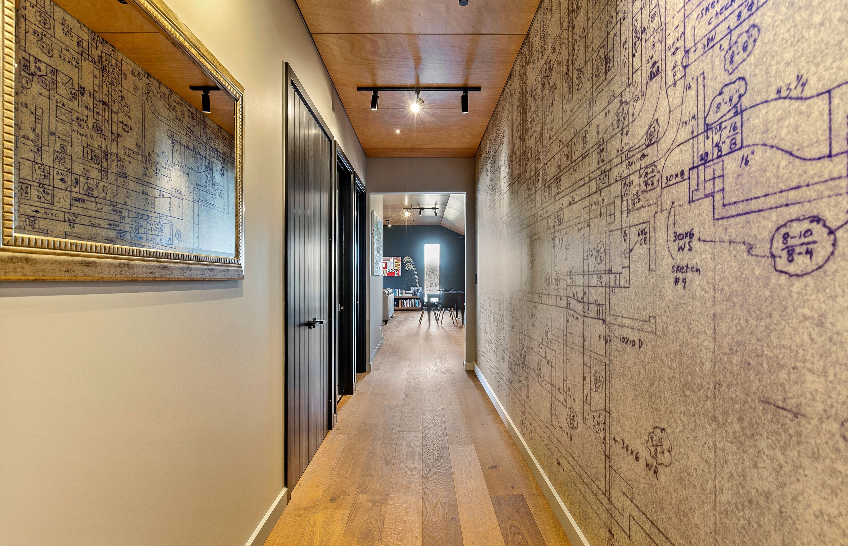 In the hallway, doors in Resene 'Double Foundry' look smart against walls painted Resene 'Napa' and a blueprint of a ventilation system, originally drawn by owners father, has been printed on vinyl as a unique piece of wall art.