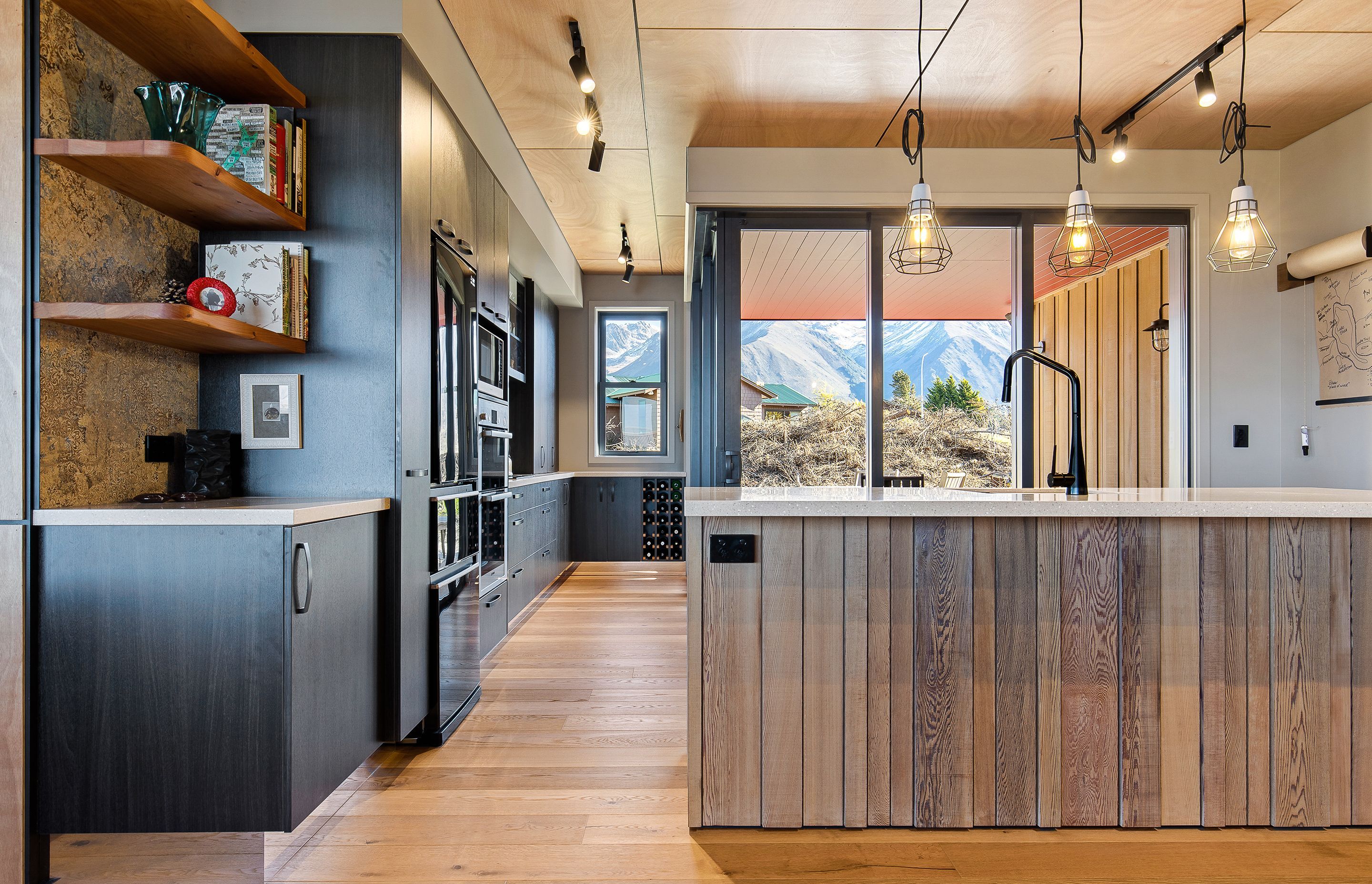 Timber panelling on the front of the island echoes the exterior cladding, and Orlando Steel Matt Black Grill pendants add an industrial edge.