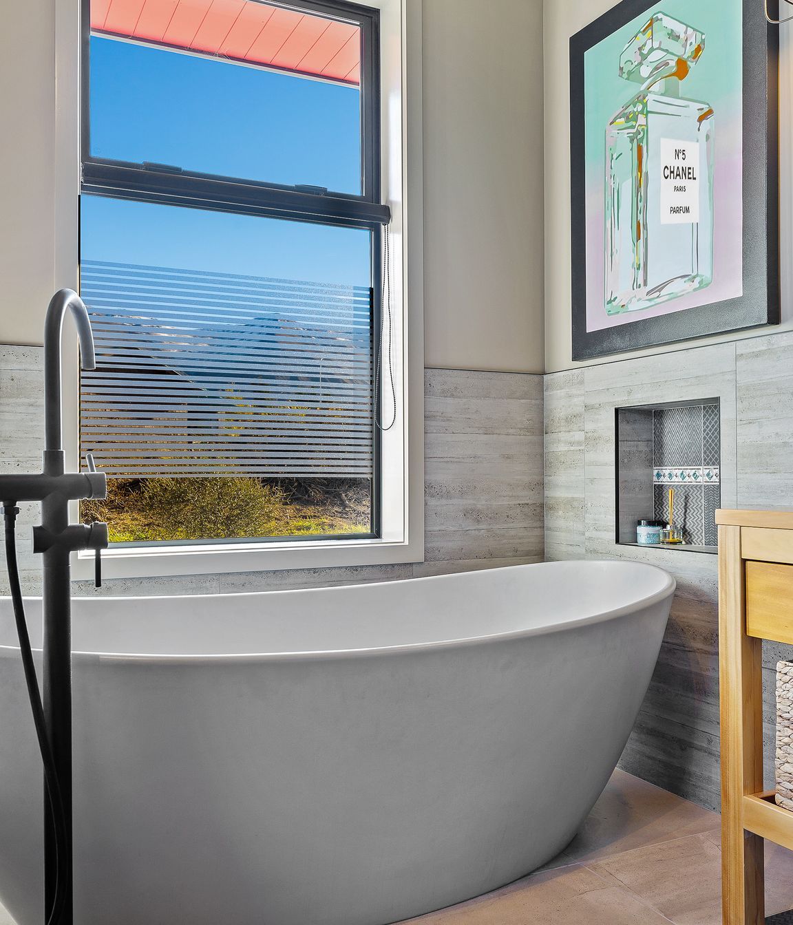 A luxurious Vivienne bathtub with organic lines was a must for long soaks in the middle of winter. Sandstone Grey Matt floor tiles and Casero Grey wall tiles continue the textural theme.