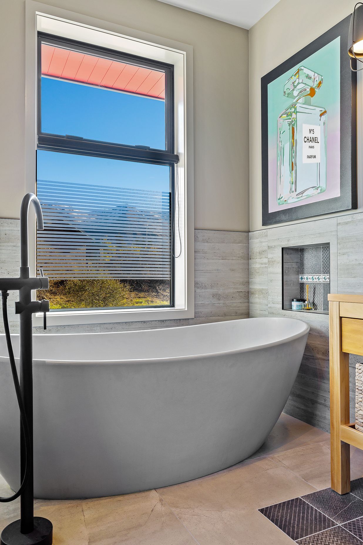 A luxurious Vivienne bathtub with organic lines was a must for long soaks in the middle of winter. Sandstone Grey Matt floor tiles and Casero Grey wall tiles continue the textural theme.