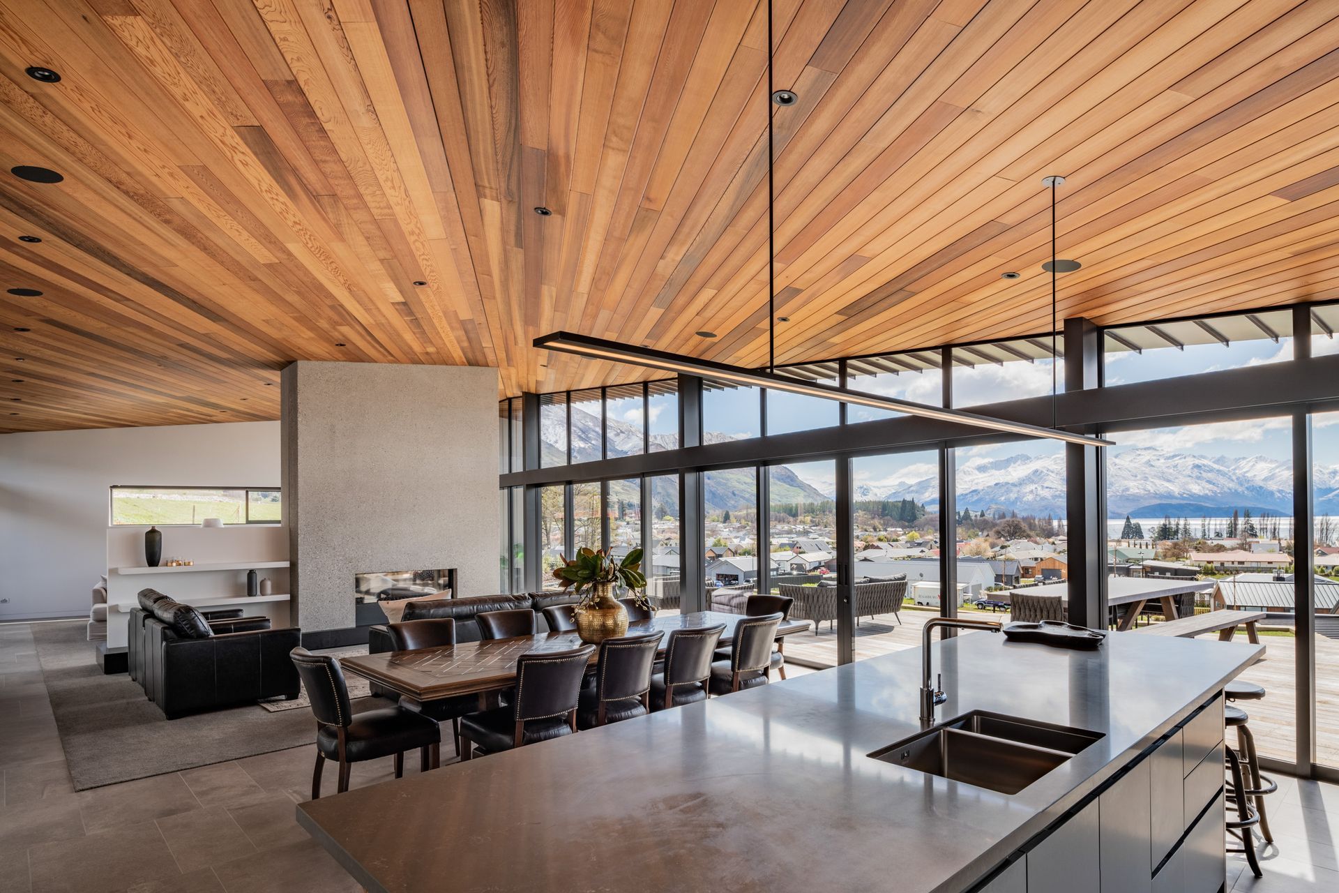 A concrete wall with double-sided gas fireplace separates the living space from a TV lounge.
