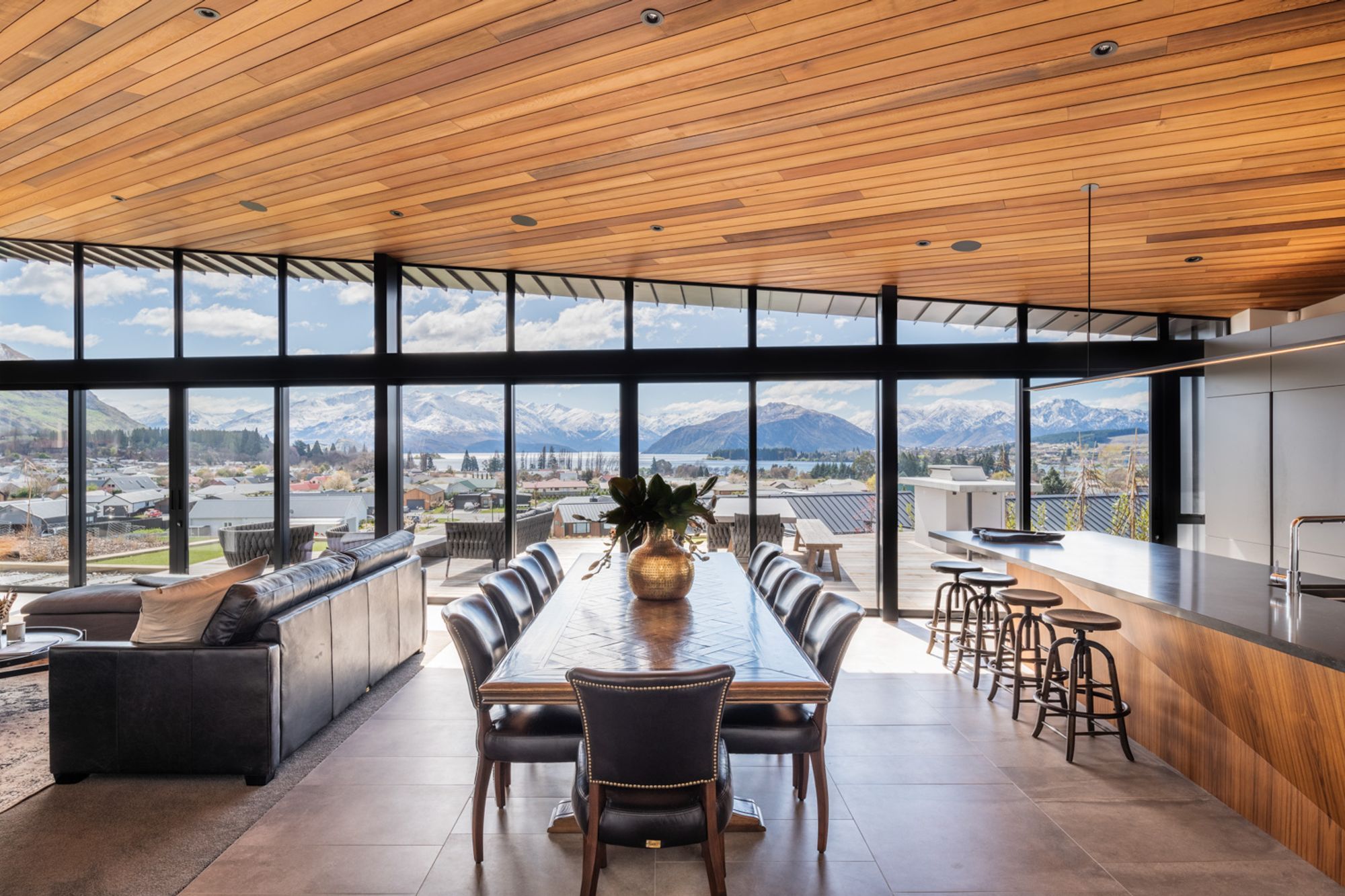 The uninterrupted views of the lake and mountains beyond is truly breathtaking, and the interior materiality reflects the earthy hues of the landscape.