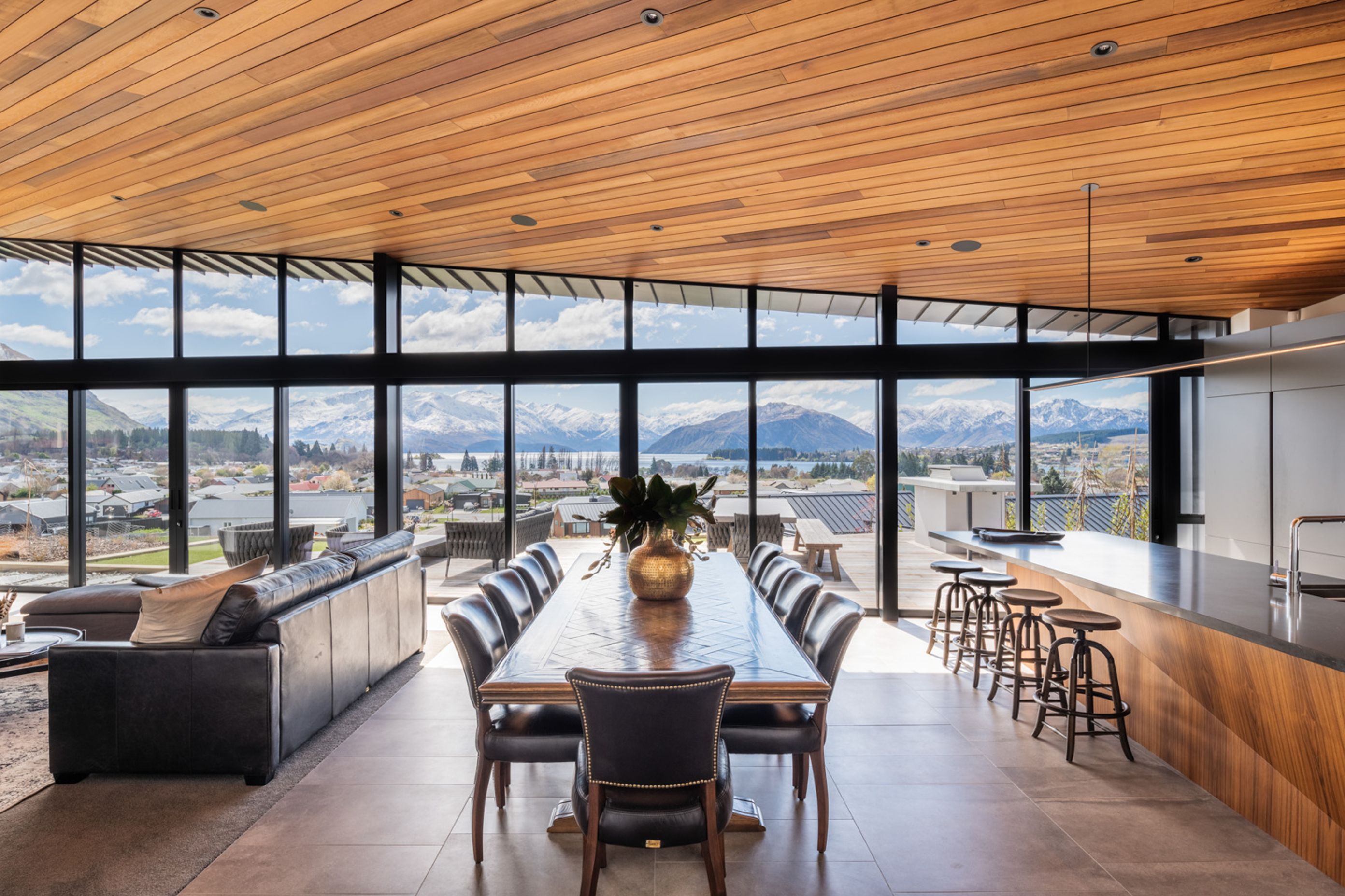The uninterrupted views of the lake and mountains beyond is truly breathtaking, and the interior materiality reflects the earthy hues of the landscape.