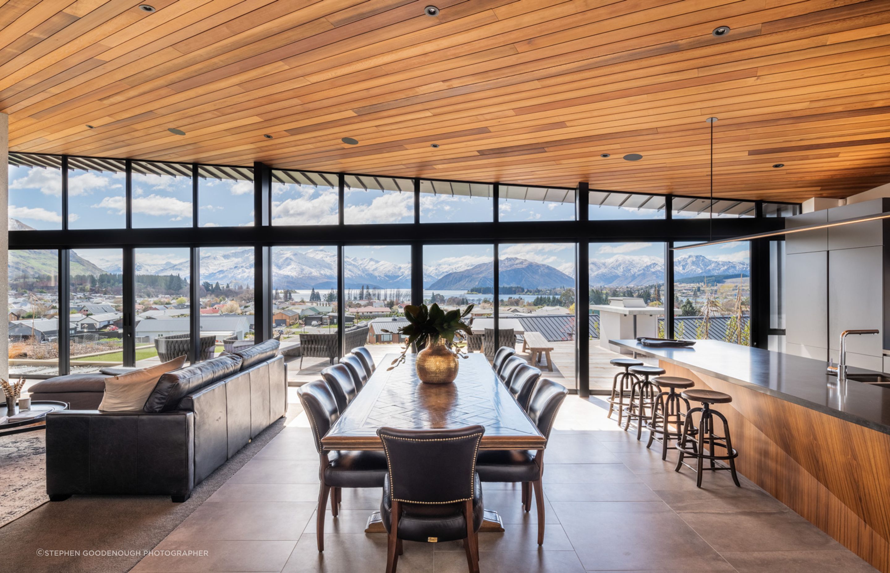 The uninterrupted views of the lake and mountains beyond is truly breathtaking, and the interior materiality reflects the earthy hues of the landscape.