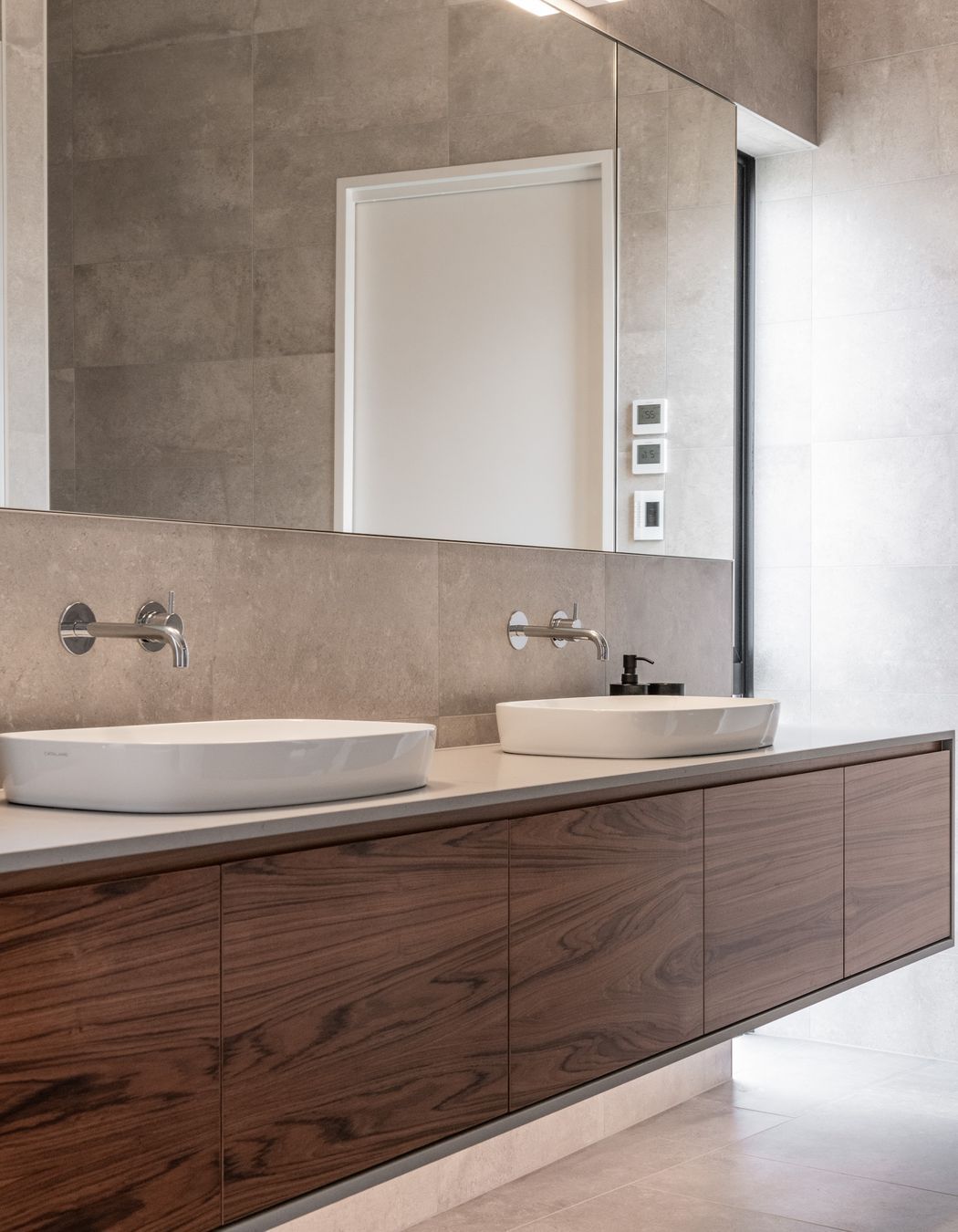 In the bathrooms a teak veneer was used to warm the otherwise serene spaces.