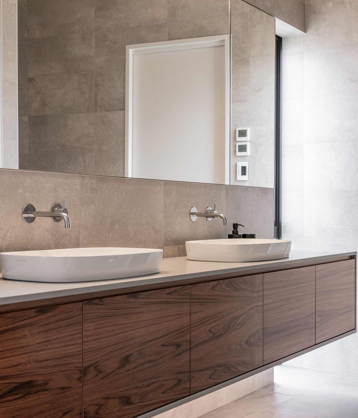 In the bathrooms a teak veneer was used to warm the otherwise serene spaces.