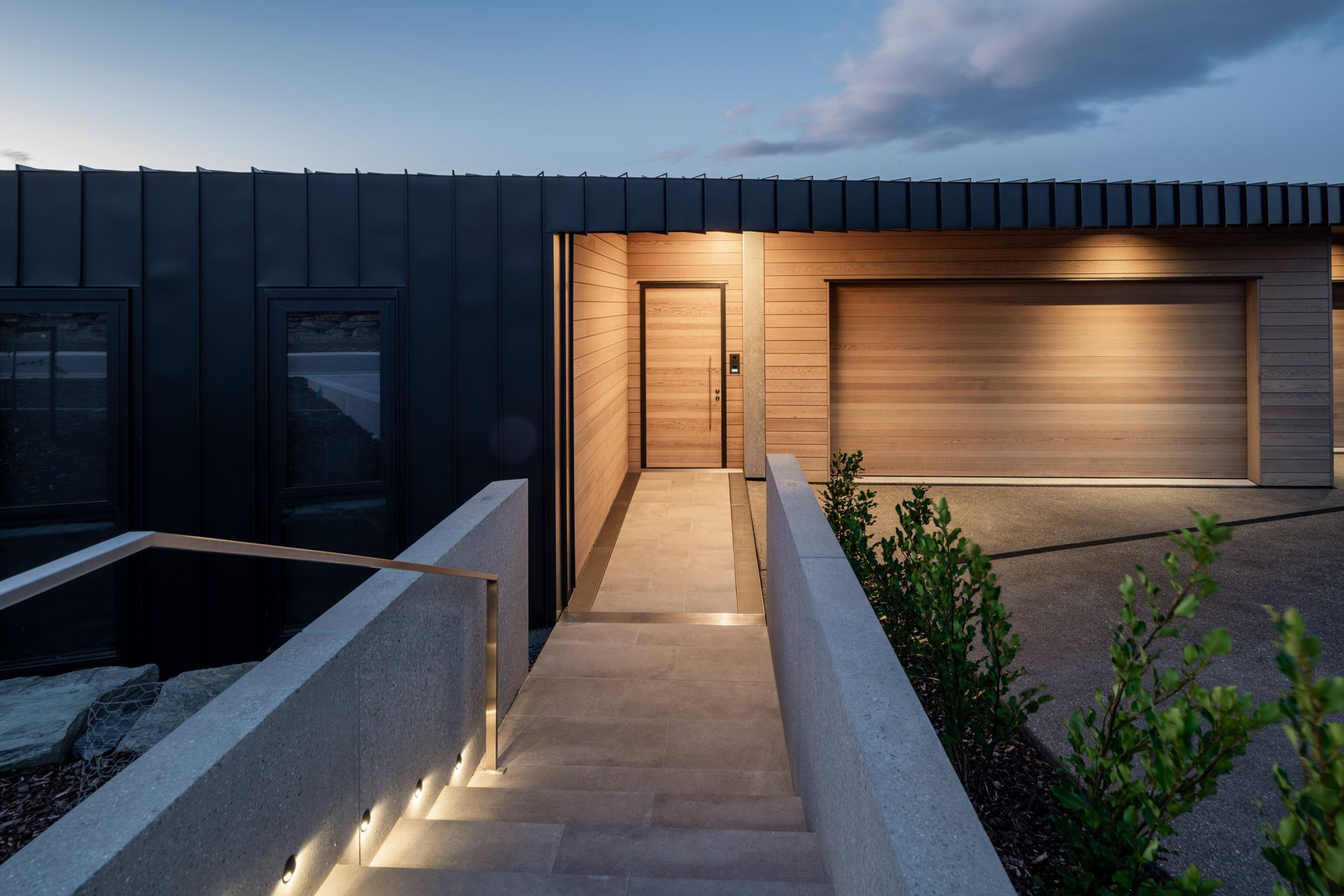 Entry spaces are accentuated with cedar to break up the black metal cladding.