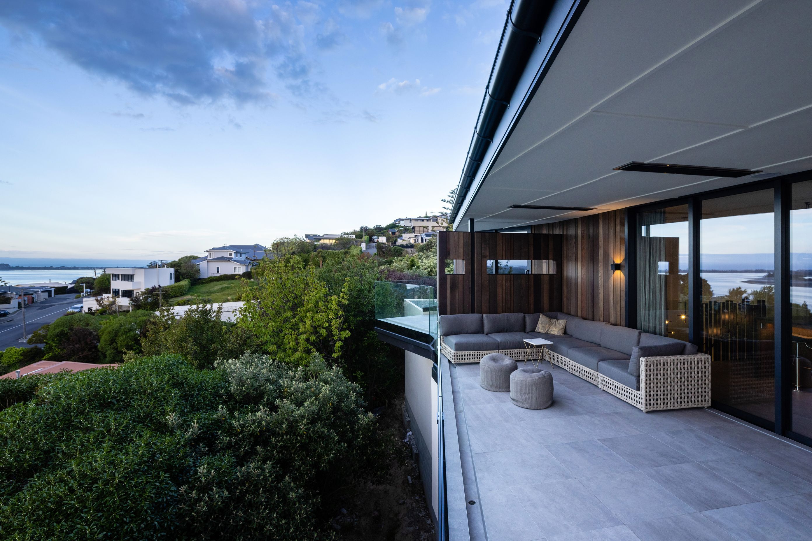A cedar clad dividing wall, separates the master bedroom balcony from the outdoor entertainment space.