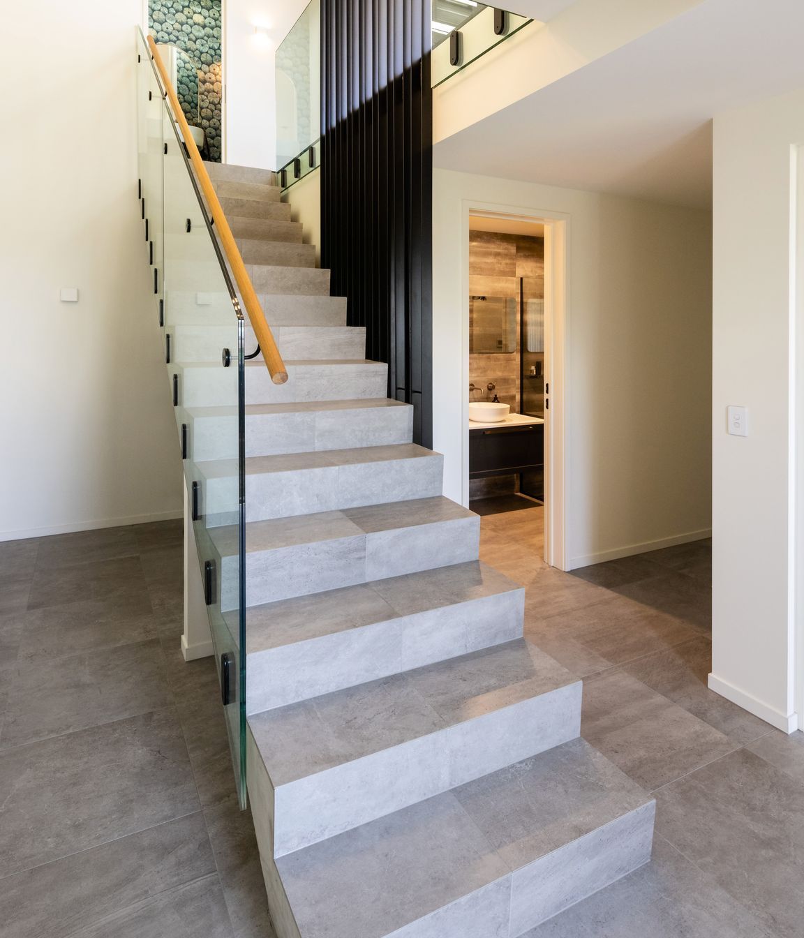 The tiled floors continue down the stair well, creating a visual continuity.