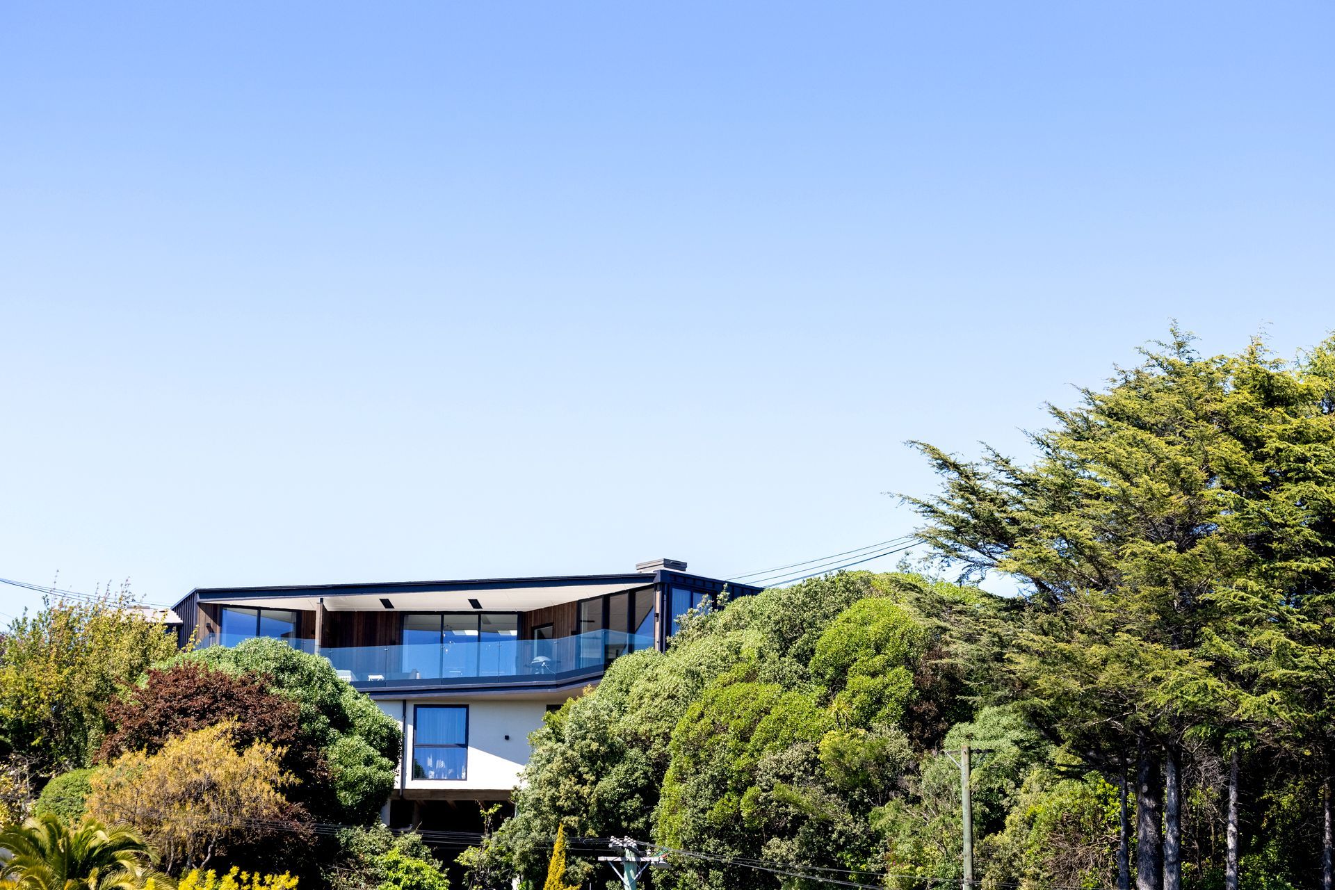 The wide eave spans the length of the first floor deck, offering shade and shelter.