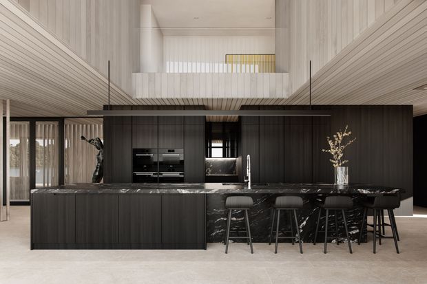 A dramatic contemporary kitchen with a large dark timber island and integrated seating, topped with a dark veined stone benchtop. Full-height dark cabinetry includes built-in appliances and a central sink. The kitchen sits within a tall open-plan interior featuring pale vertically panelled walls and ceiling, a suspended linear pendant, clerestory-style glazing, and a mezzanine balustrade. The palette is predominantly black, charcoal, warm grey, and pale neutral tones.