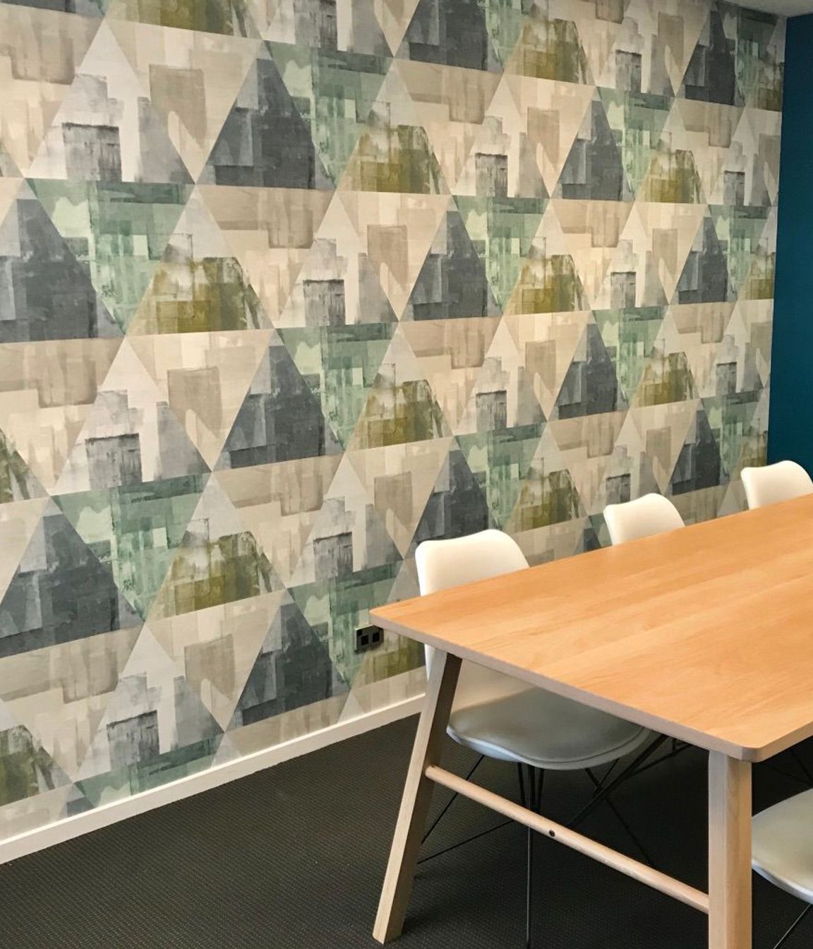 Wallpaper in a large scale mid century inspired design makes a statement in this boardroom space.