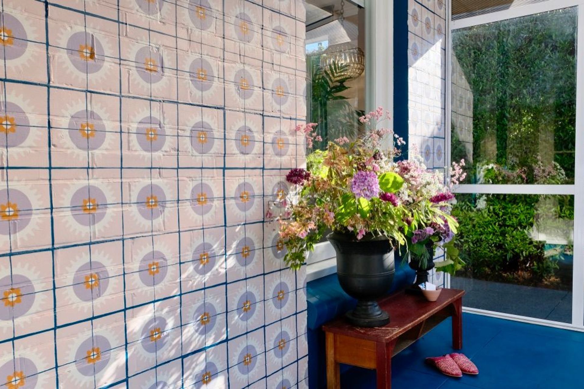 Many many hours of tiles stencilled over bricks transformed this dreary entranceway. Beautiful work by Samantha Elise Studio.