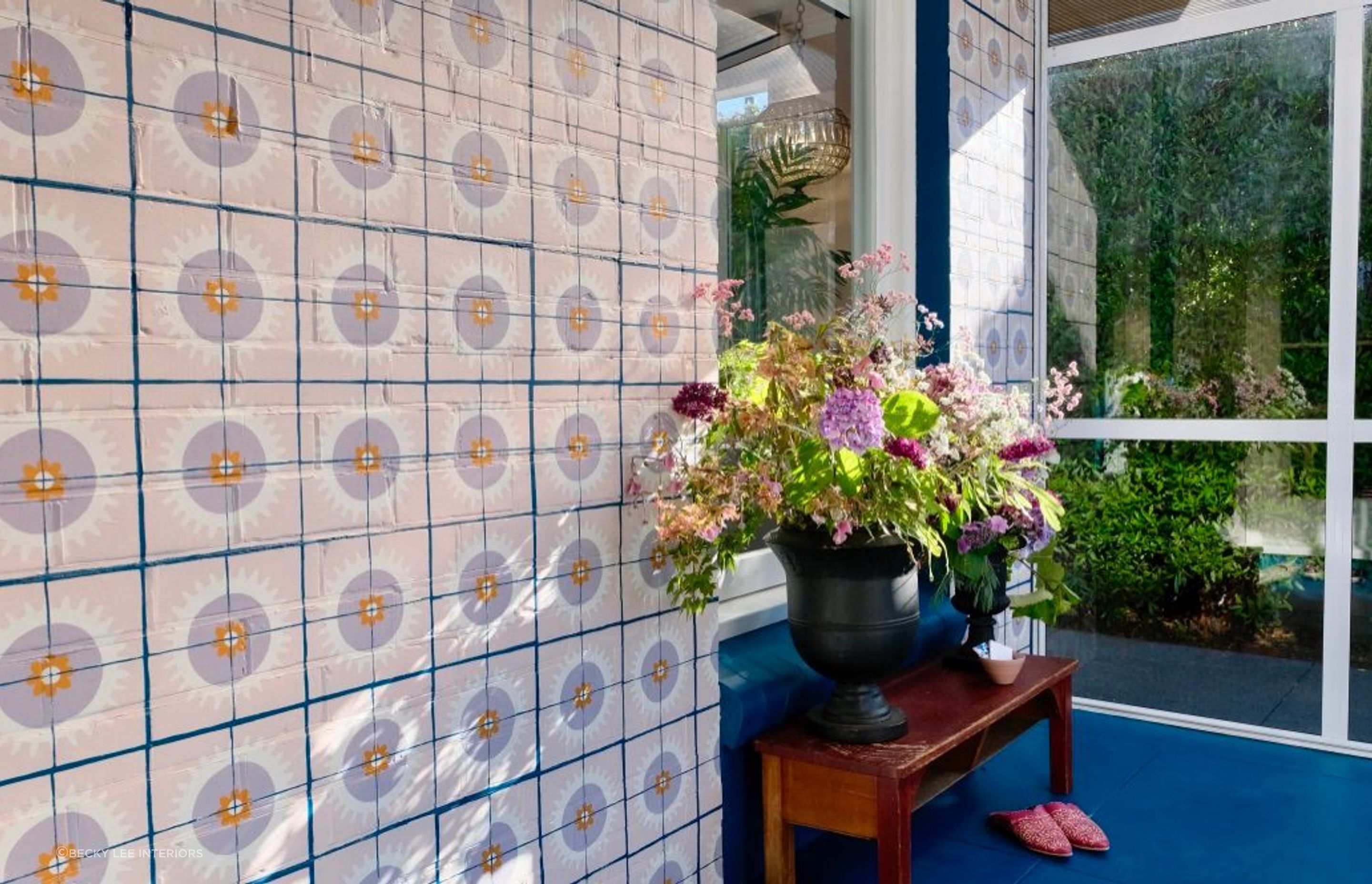 Many many hours of tiles stencilled over bricks transformed this dreary entranceway. Beautiful work by Samantha Elise Studio.