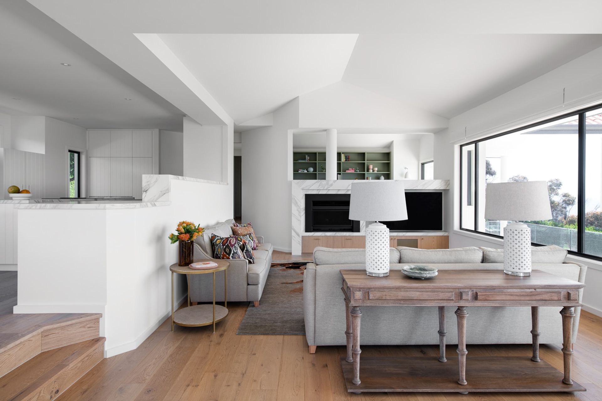 Open plan interior design featuring a fireplace & custom joinery.