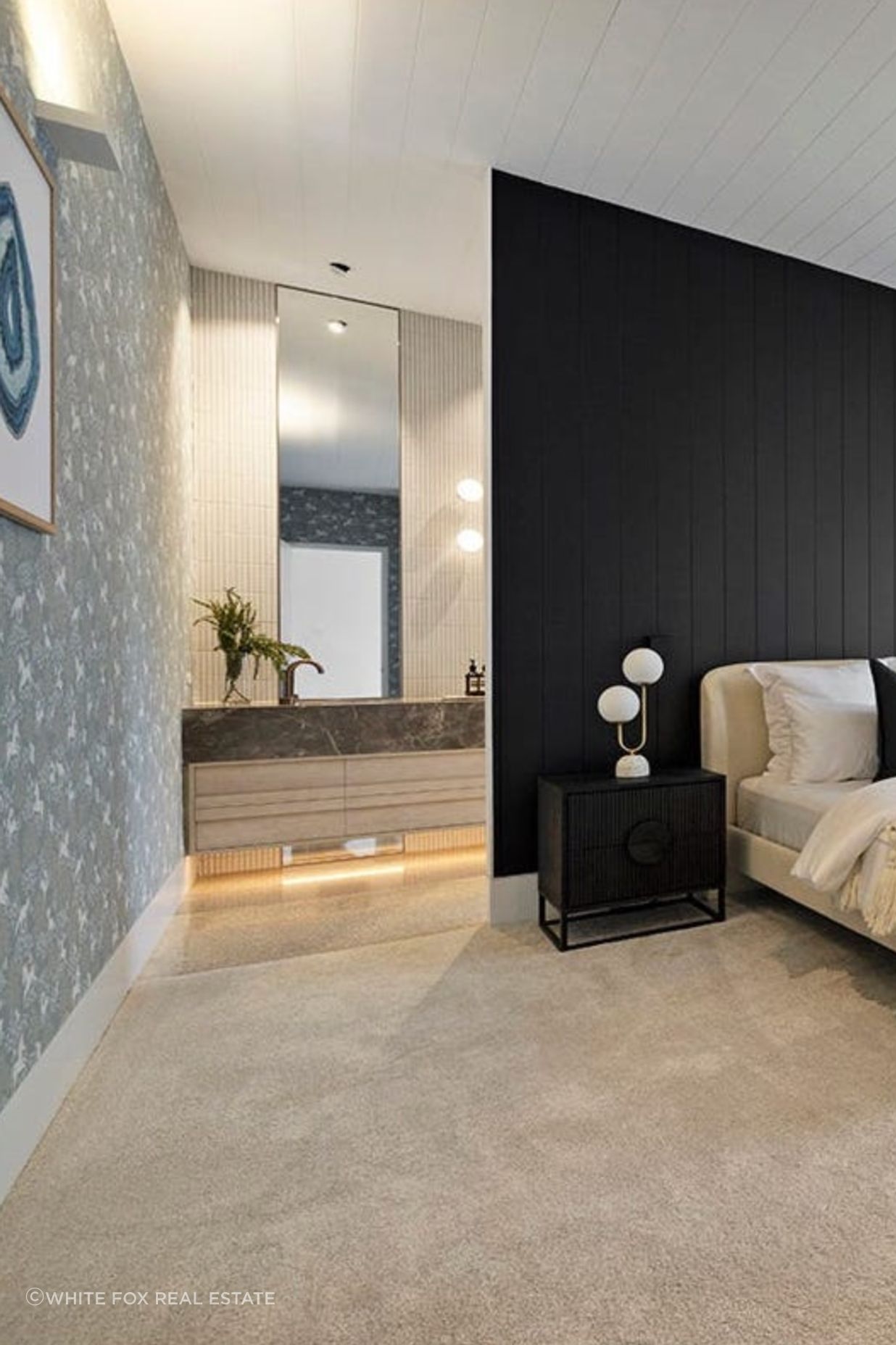 The master bedroom entrance to the ensuite is illuminated by uplights and large mirrors
