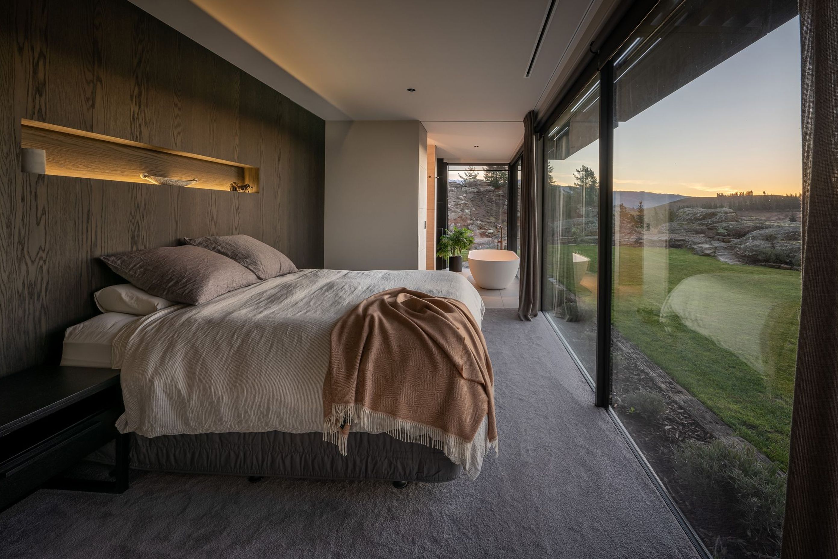 The master bedroom enjoys uninterrupted views through floor-to-ceiling glazing.