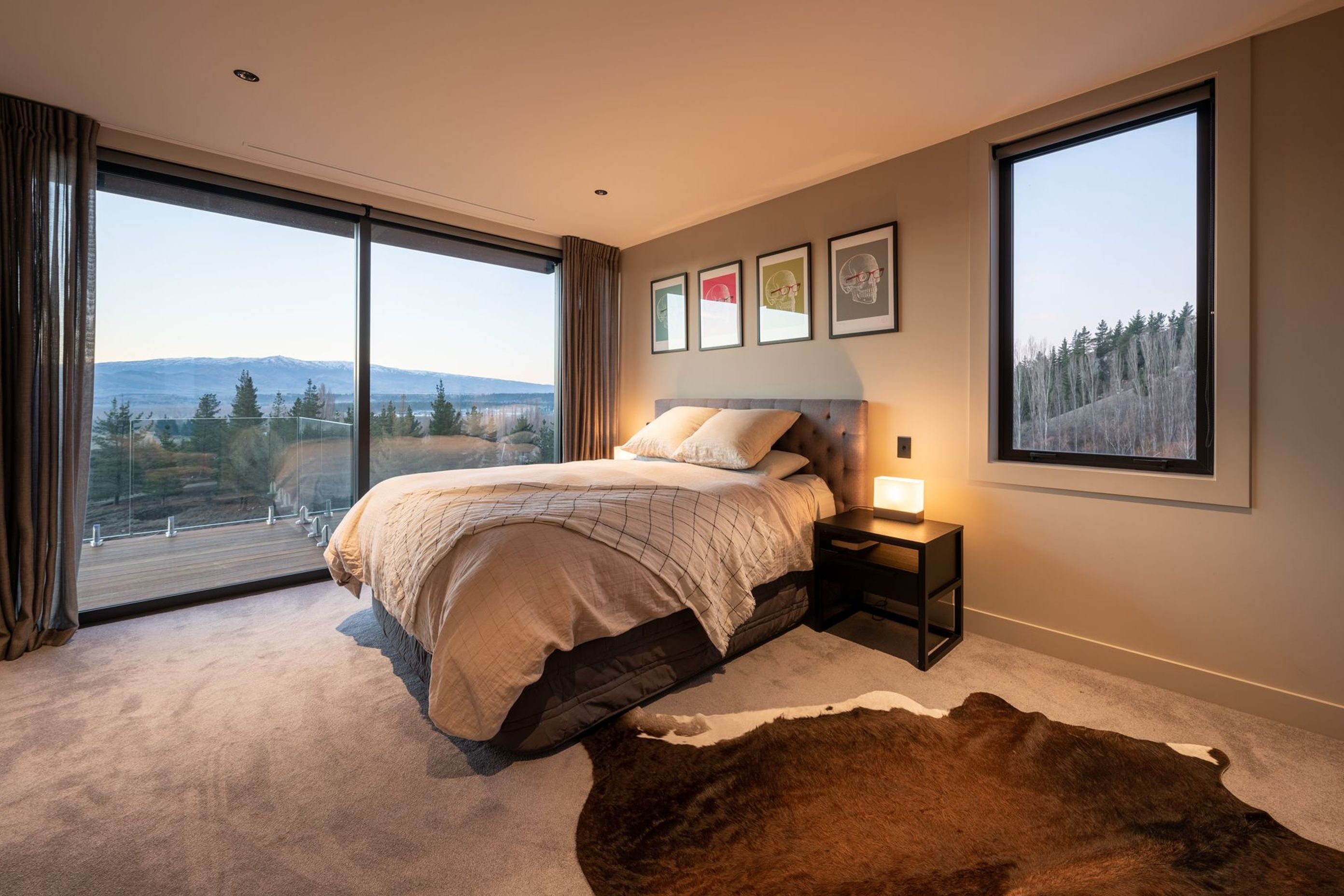 A large bedroom above the garage in the guest/family wing has a perfect picture window next to the bed that takes in a snapshot of the forest beyond.