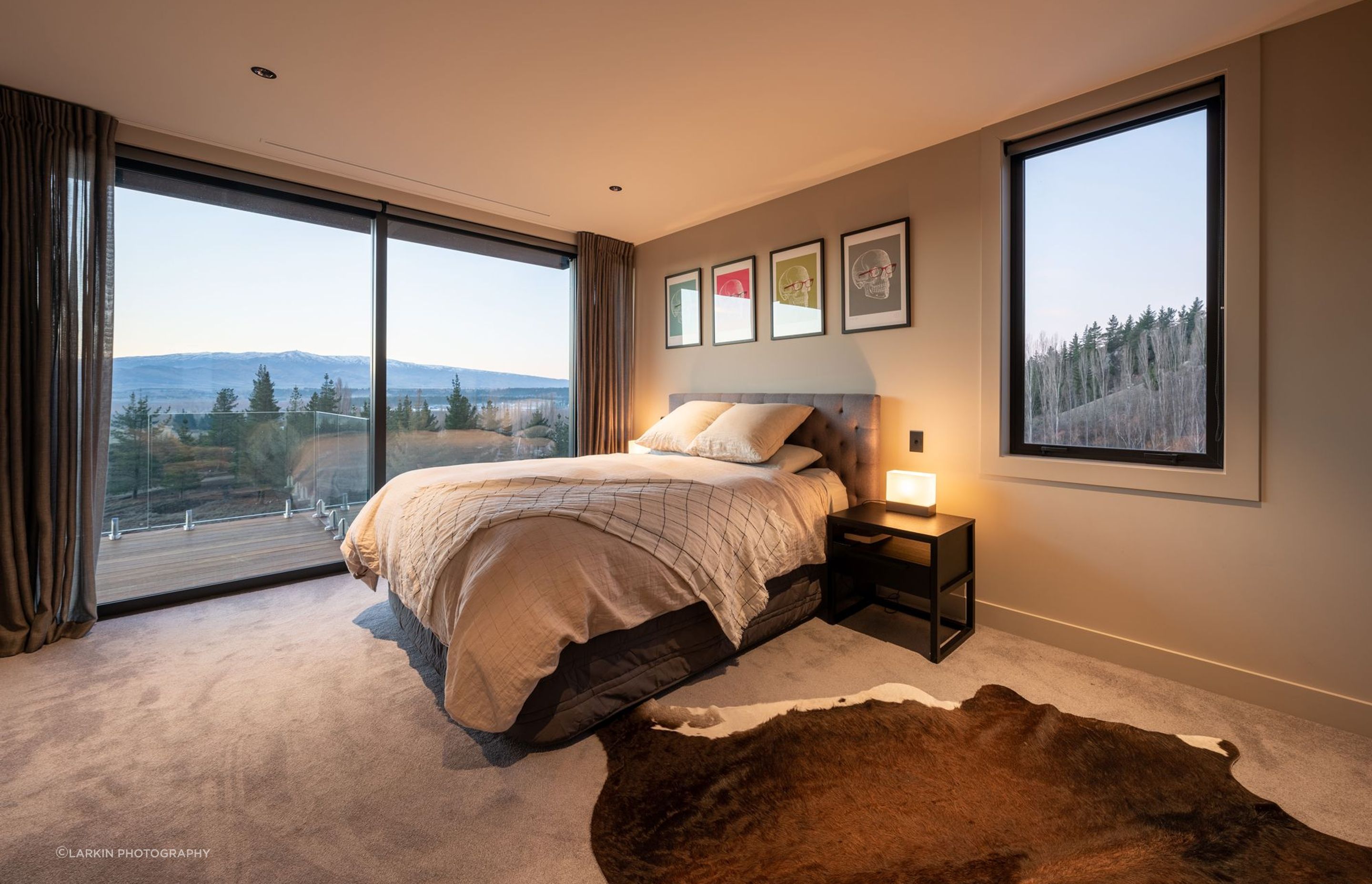 A large bedroom above the garage in the guest/family wing has a perfect picture window next to the bed that takes in a snapshot of the forest beyond.